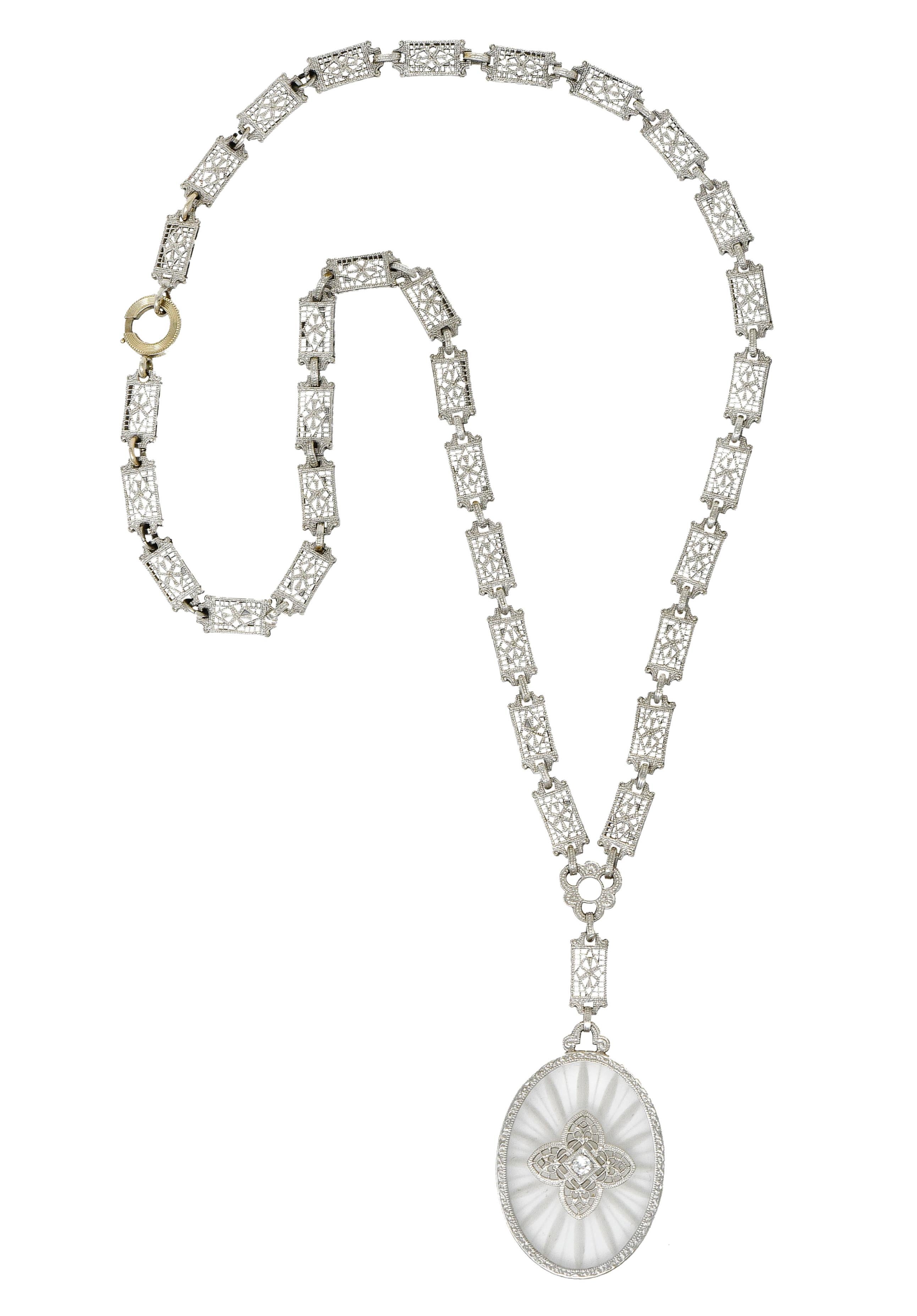Featuring a drop designed as a bezel set oval of camphor glass frosted with a radiating burst motif

With a pierced floral motif accented by a round brilliant cut diamond weighing approximately 0.10 carat, eye-clean and white

Suspended on a