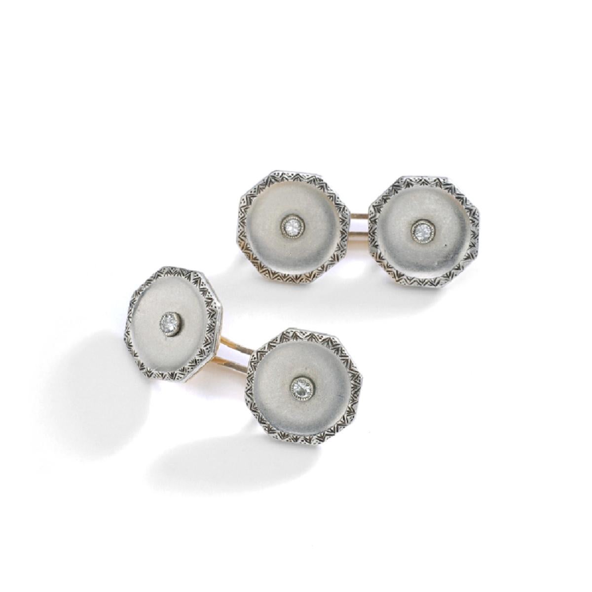 So Art Deco! A pair of platinum and gold cufflinks. The platinum is matte and has geometric typical Art Deco patterns on borders. Centered each one by a small diamond. 
Circa 1920.

Total weight: 14.72 grams
