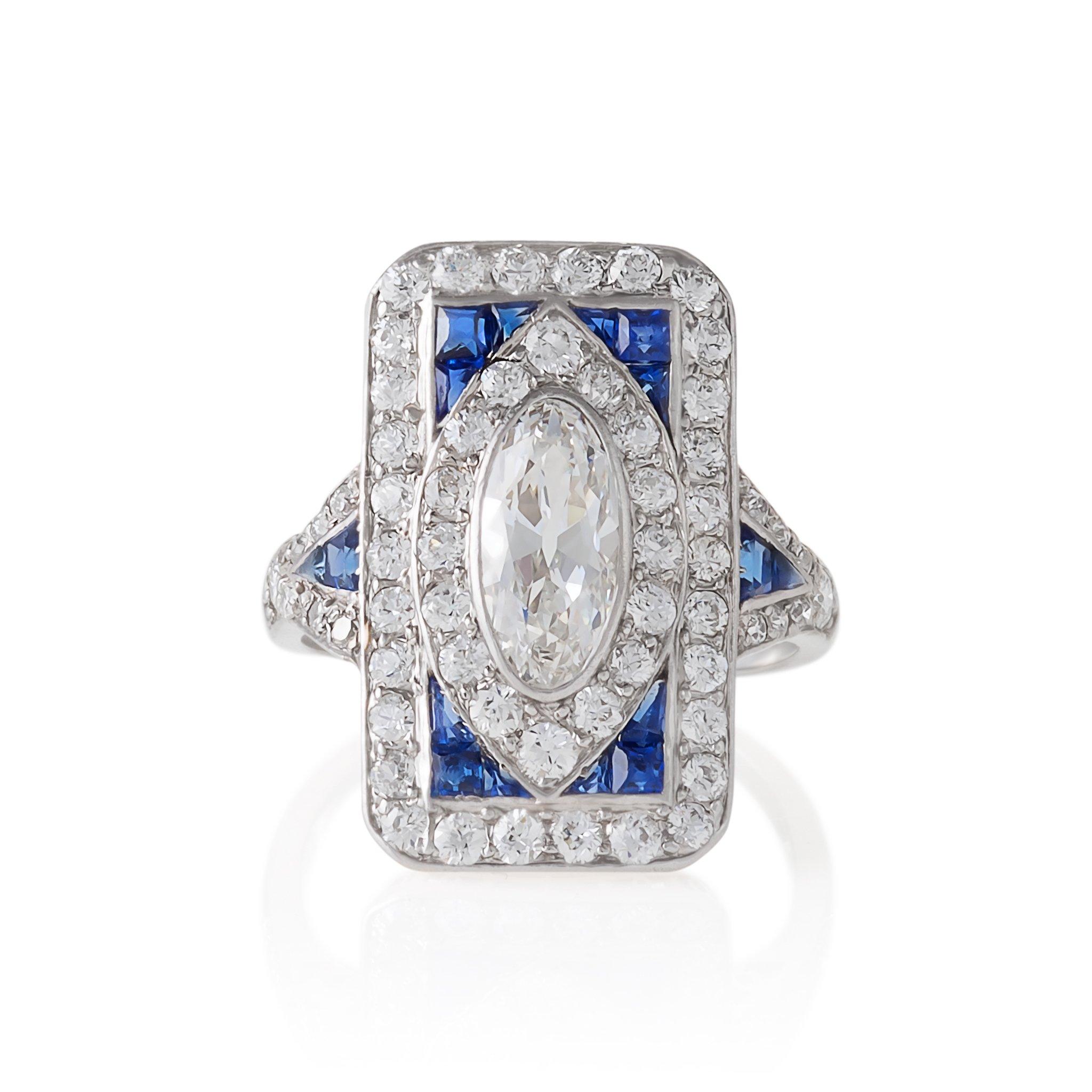 An Art Deco platinum ring with diamonds and sapphires. The ring has a center oval diamond with an approximate total weight of .80 carat, I/J color, VS clarity and 60 old European-cut diamonds with an approximate total weight of 1.20 carats, and 12