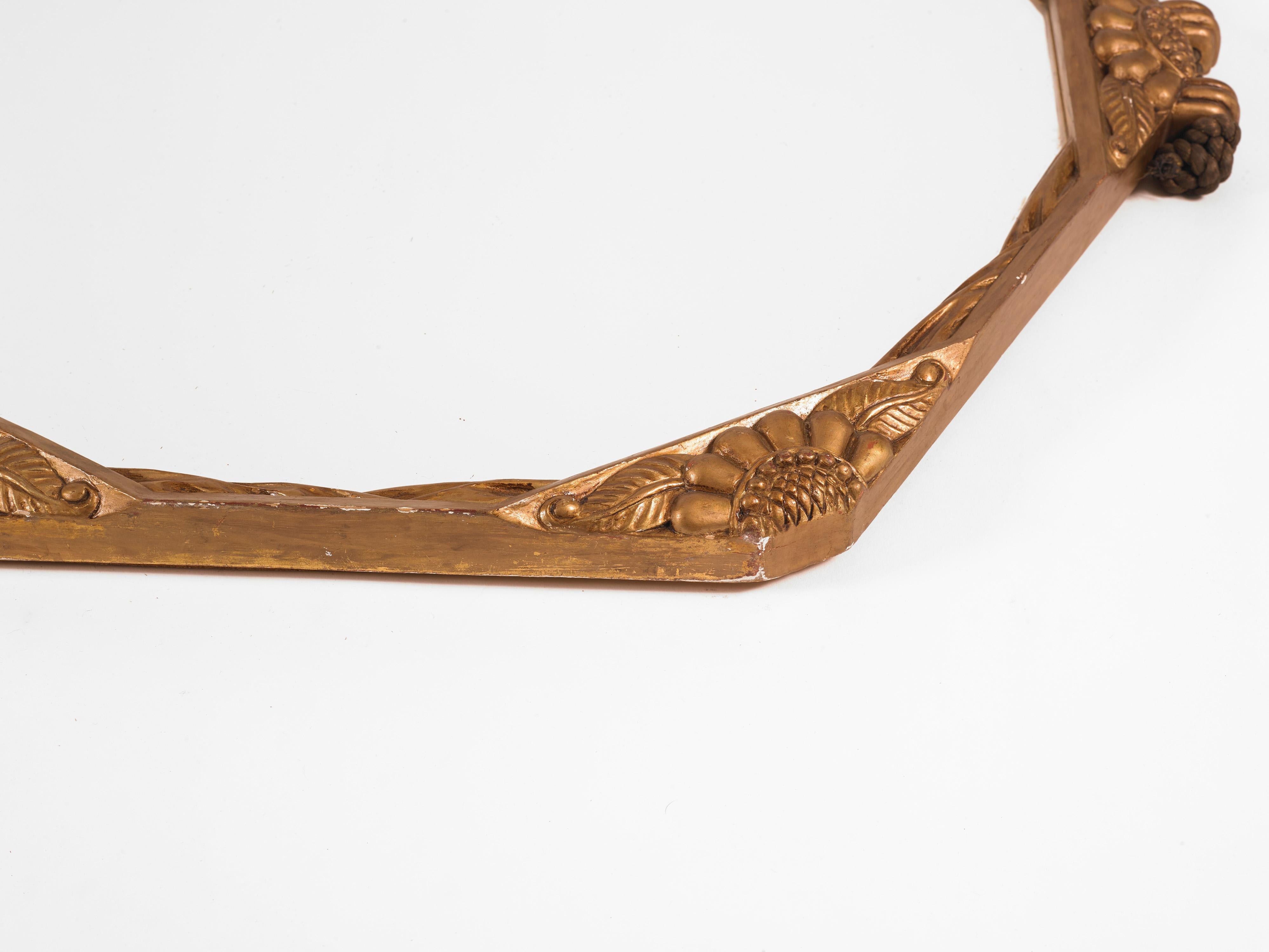 Offered is a hexagonal-shaped gilt-framed round mirror made in France circa. the mid to late 1920s. The curved gold leaf frame features carvings with flower petals at each of the six tips along the rim. 

It measures approximately 24