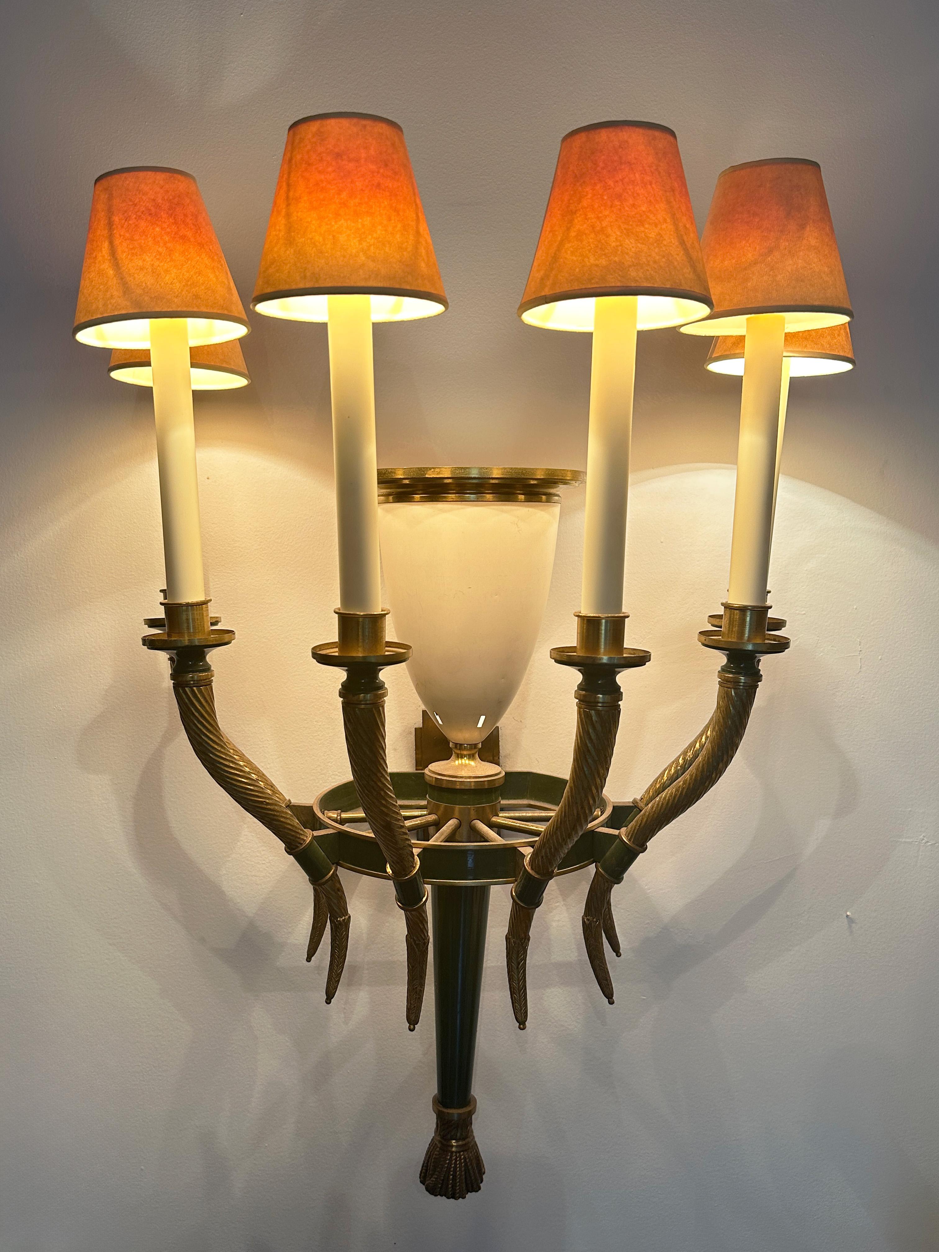 Large brass wall sconce with green paint detals. This beautiful and unique piece has 6 arms that surround the main center white metal light bowl with a brass stepped ring. Each arm has a candle stick light source that holds a candelabra light bulb