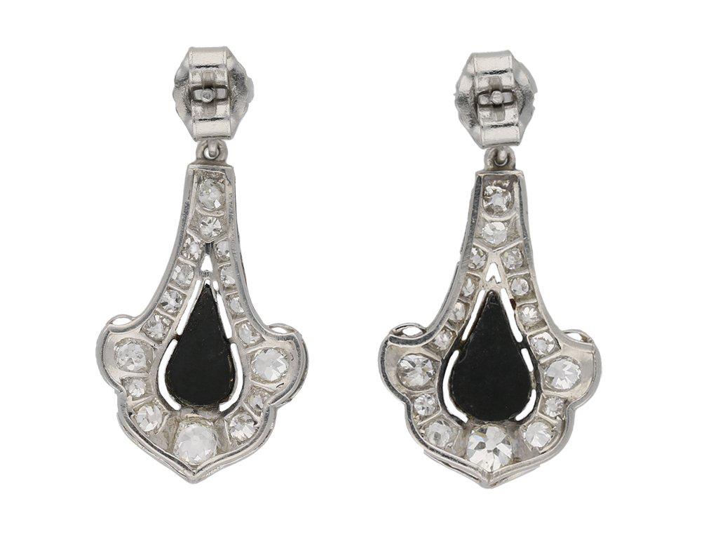 Art Deco onyx and diamond earrings. A matching pair, each set with one drop shape cabochon onyx in open back rubover and millegrain settings, set to top with one round old cut diamond in open back rubover and millegrain settings, two in total with a
