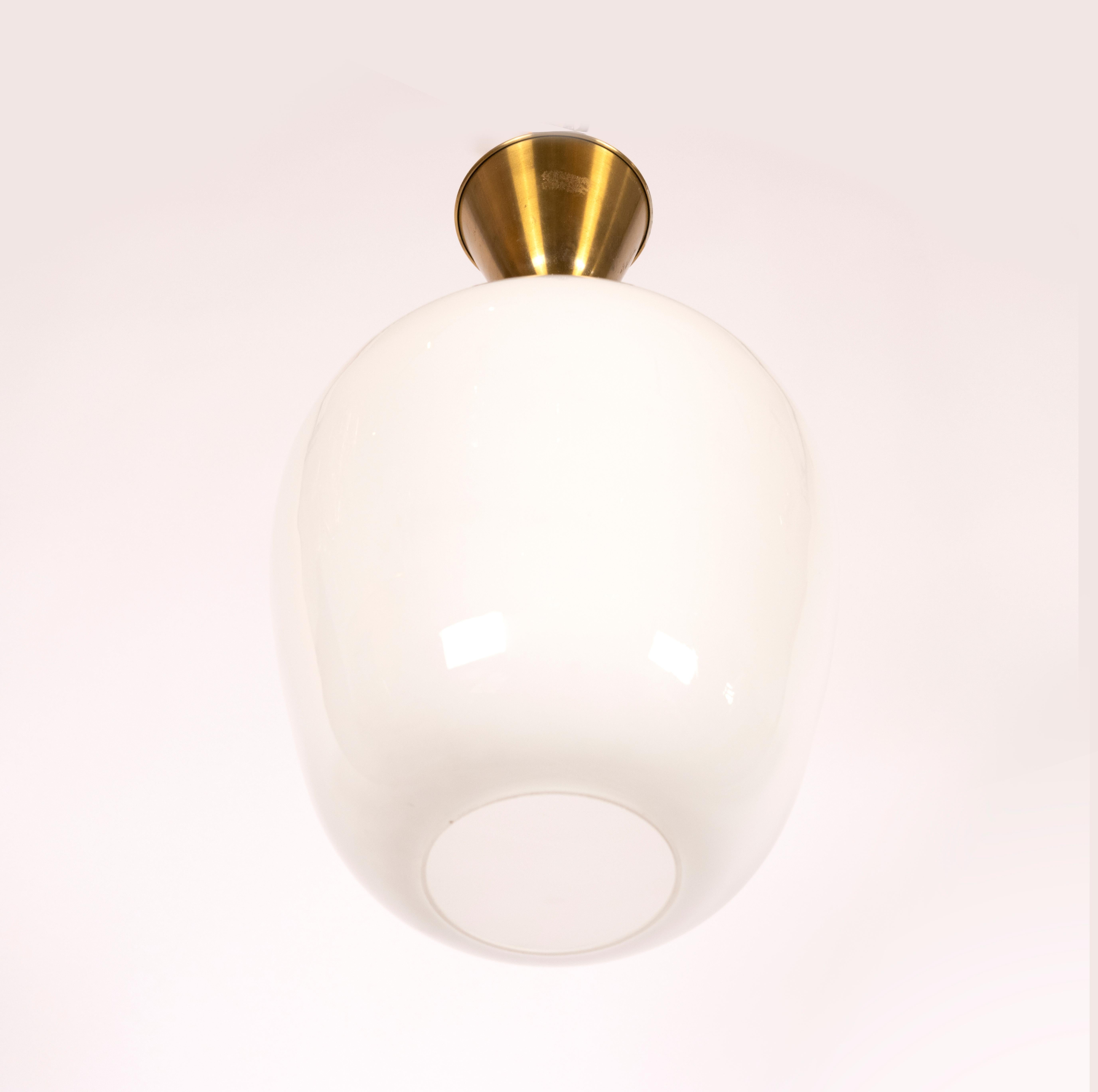 An Art Deco opal glass pendant with brass stem and canopy. Standard Wiring included in pricing.