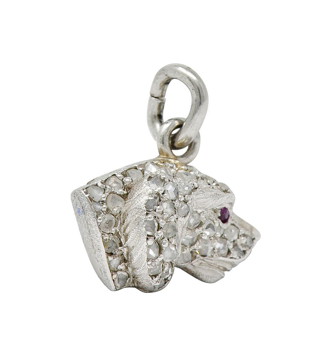 Charm is designed as a profile of a dog with a ruby eye accent

Pavè set throughout by rose cut diamonds weighing approximately 0.50 carat

Quality consistent with age

Tested as platinum

Circa: 1920s

Measures: 1/2 x 1/2 inch (including jump ring