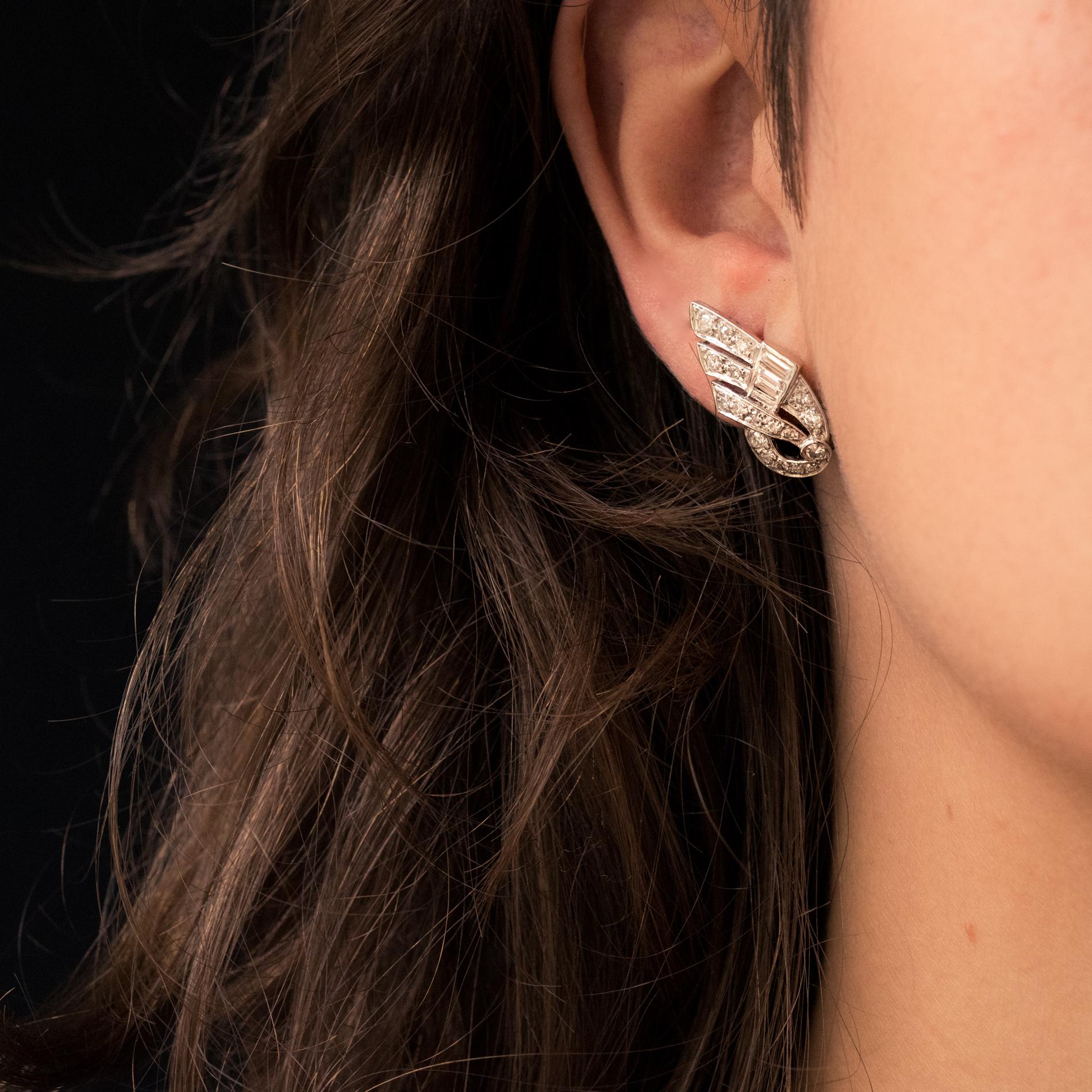 For pierced ears.
Pair of ear clips in platinum, dog's head hallmark and 18 karat white gold, eagle's head hallmark.
Each of these earrings, in the shape of an extended wing, is set with brilliant-cut and baguette-cut diamonds. The attachment system