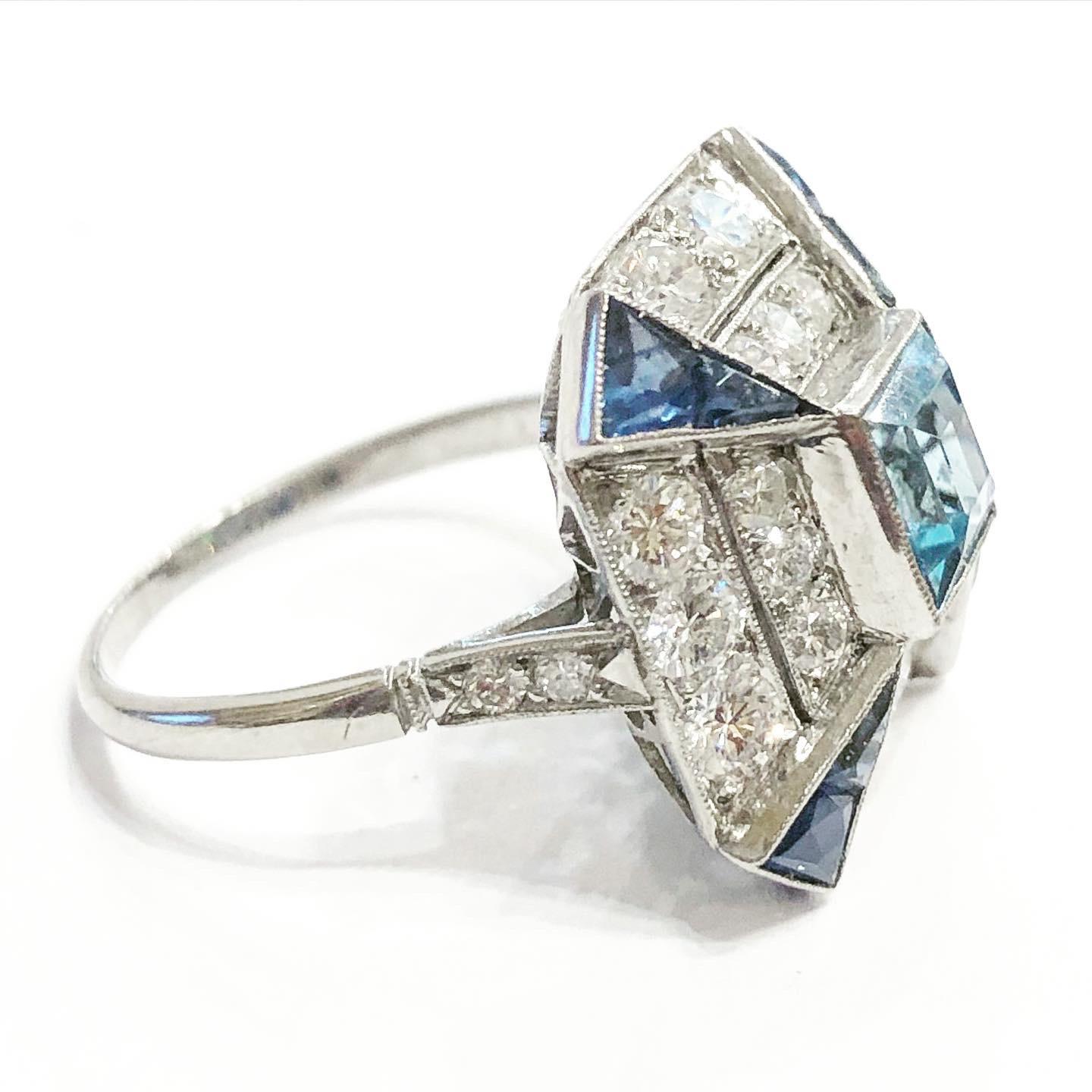 Stunning Platinum, aquamarine, diamonds and blue sapphire Art Deco cocktail ring.
France, circa 1930. Art Deco. Condition: Good.
Brilliant-cut diamonds. Emerald cut aquamarine. French cut sapphires.
Total approximate diamond carat weight: 1.4