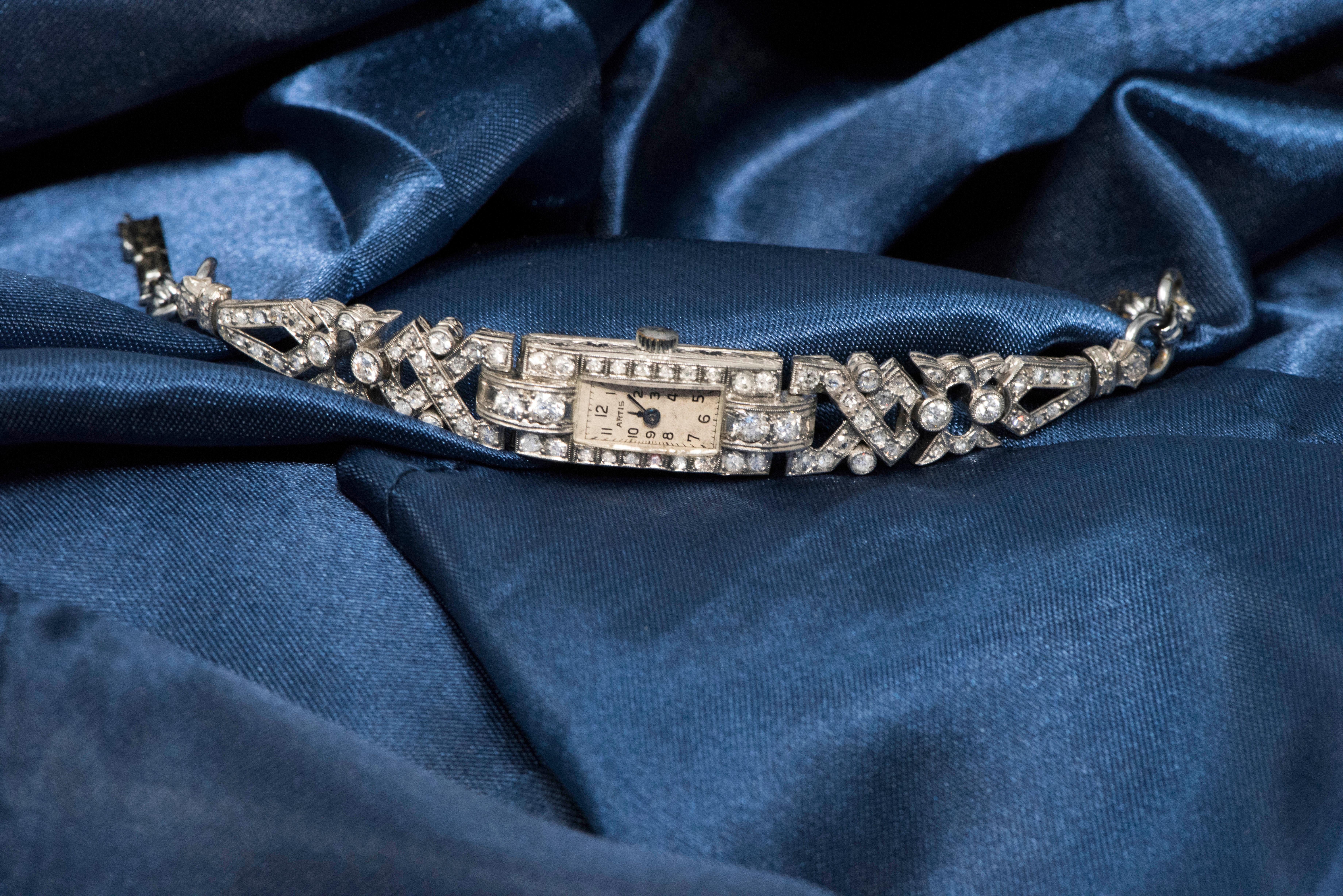 The present Timepiece is an elegant and sophisticated 1920s Art Deco, Platinum Diamond Set Egyptian revival motif Bracelet watch.

The bracelet is designed with an intricately planned Egyptian revival motif concept of interwoven triangular and