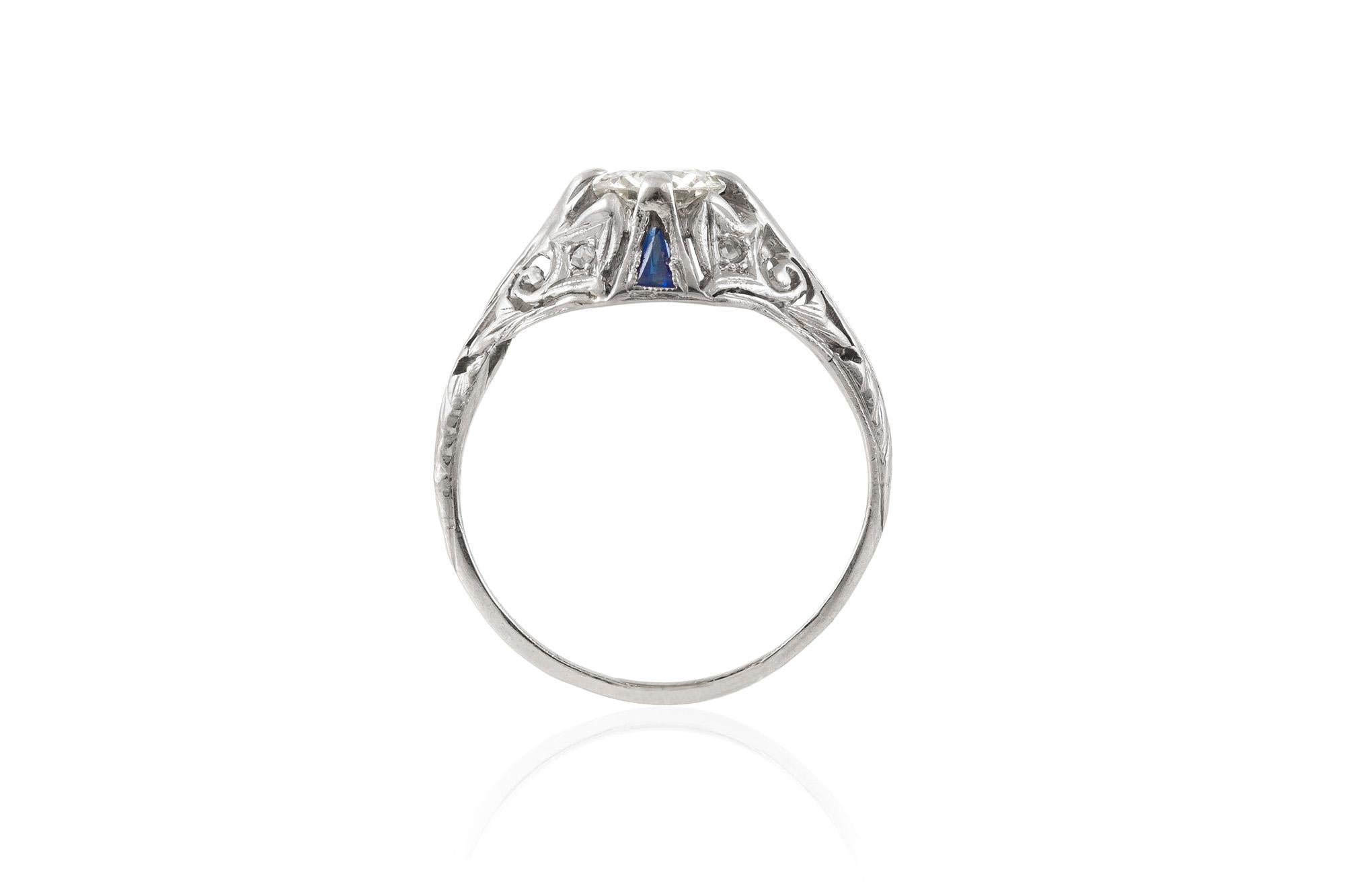 The beautiful ring is finely crafted in platinum with filigree. The center diamond weighs approximately a total of 0.67 carat. The ring features sapphires on the side.
Circa 1920.