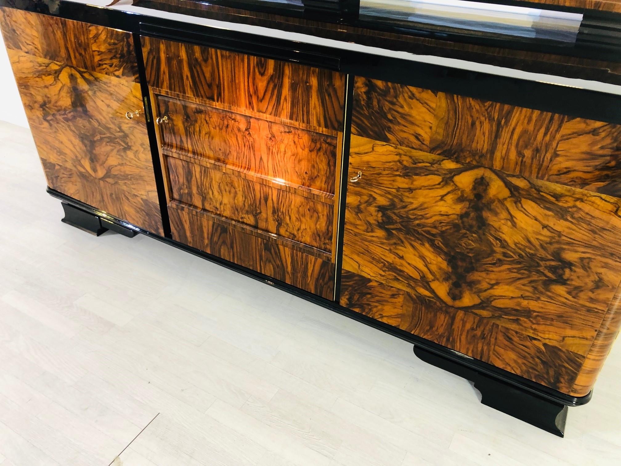 Original Art Deco large sideboard or buffet with a beautifully winged hutch on the buffet top. Convinces with its stunning body with amazing Caucasian walnut burl, layed out perfectly bookmatched on the outer doors. Restored to a perfect condition