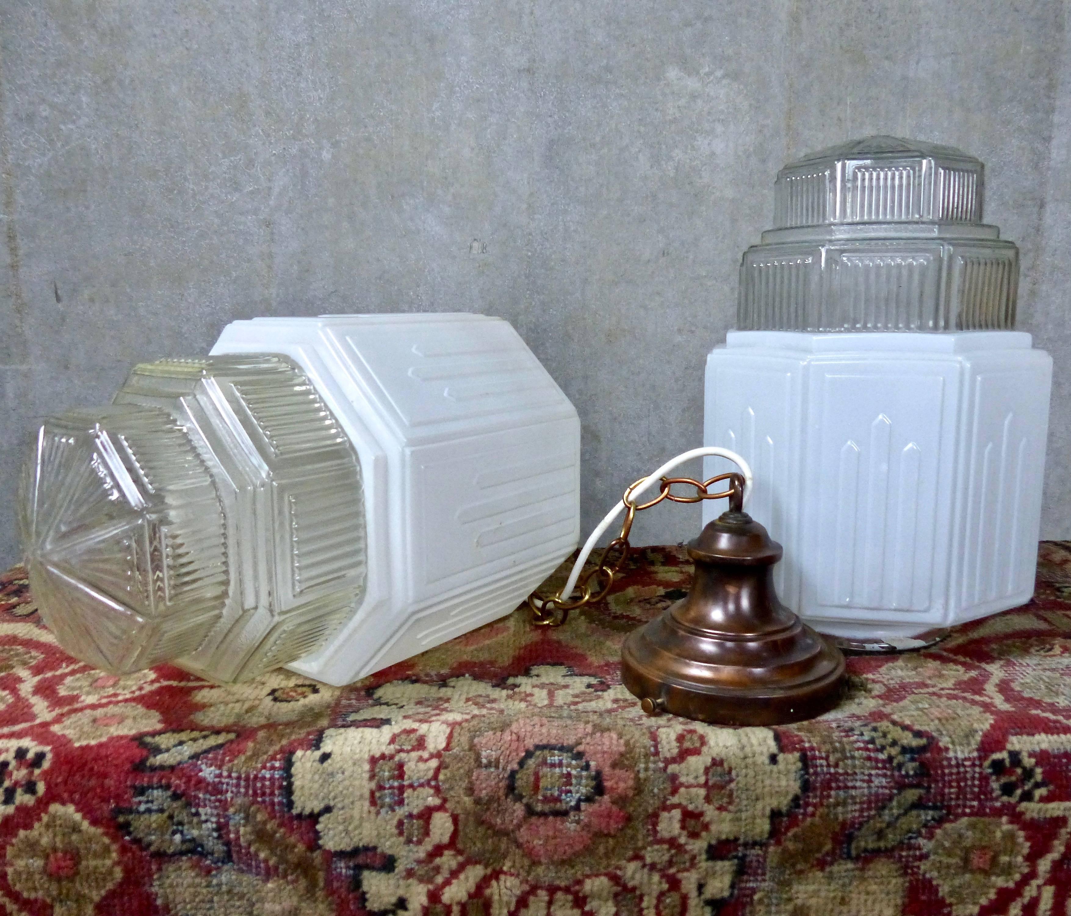 A rare pair of original Art Deco pendant lights in a Classic New York skyline shape. Milk glass uppers; pyramid-shaped clear glass on lower portion. Re-wired and CSA approved; 
copper ceiling mounts included. 

 