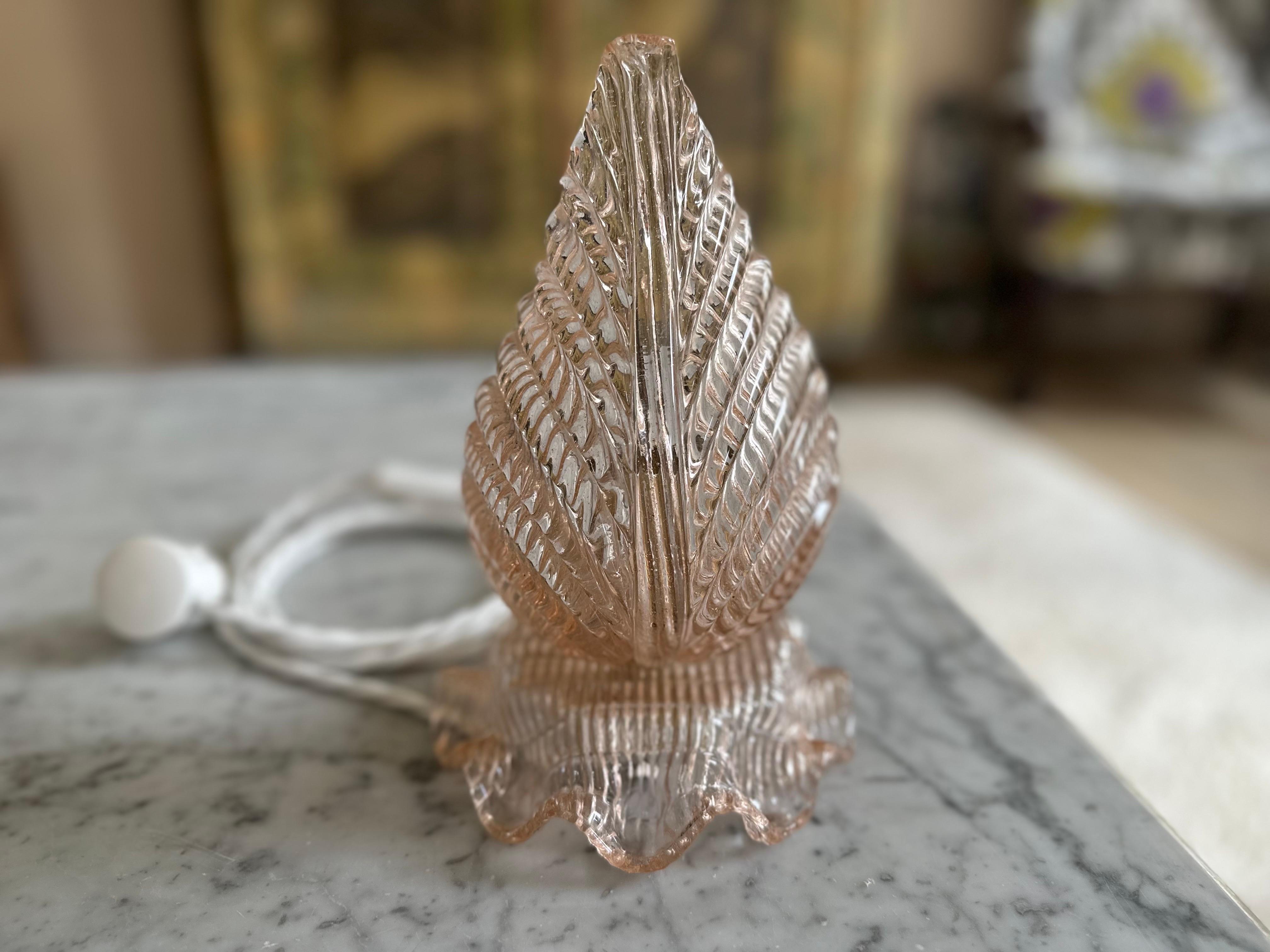 This enchanting table lamp from the 1920s is a true eye-catcher – not only because of its elegant Art Deco shape, but also thanks to its soft rose-colored Murano glass. Most likely crafted by renowned glass artist Ercole Barovier, the thick,