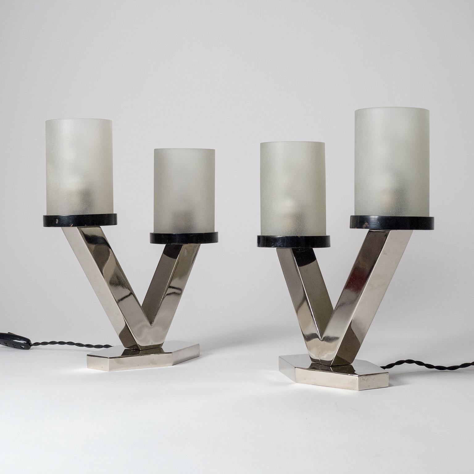 Superb pair of nickelled Art Deco table lamps with frosted glass diffusers, circa 1920. Clean geometric design with a nice asymmetric touch. Nickelled steel base with two asymmetric arms, each holding a lacquered wood disc which supports a thick