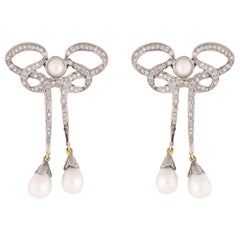 Boucles d'oreilles en forme de nœud de style Art déco avec diamants et perles