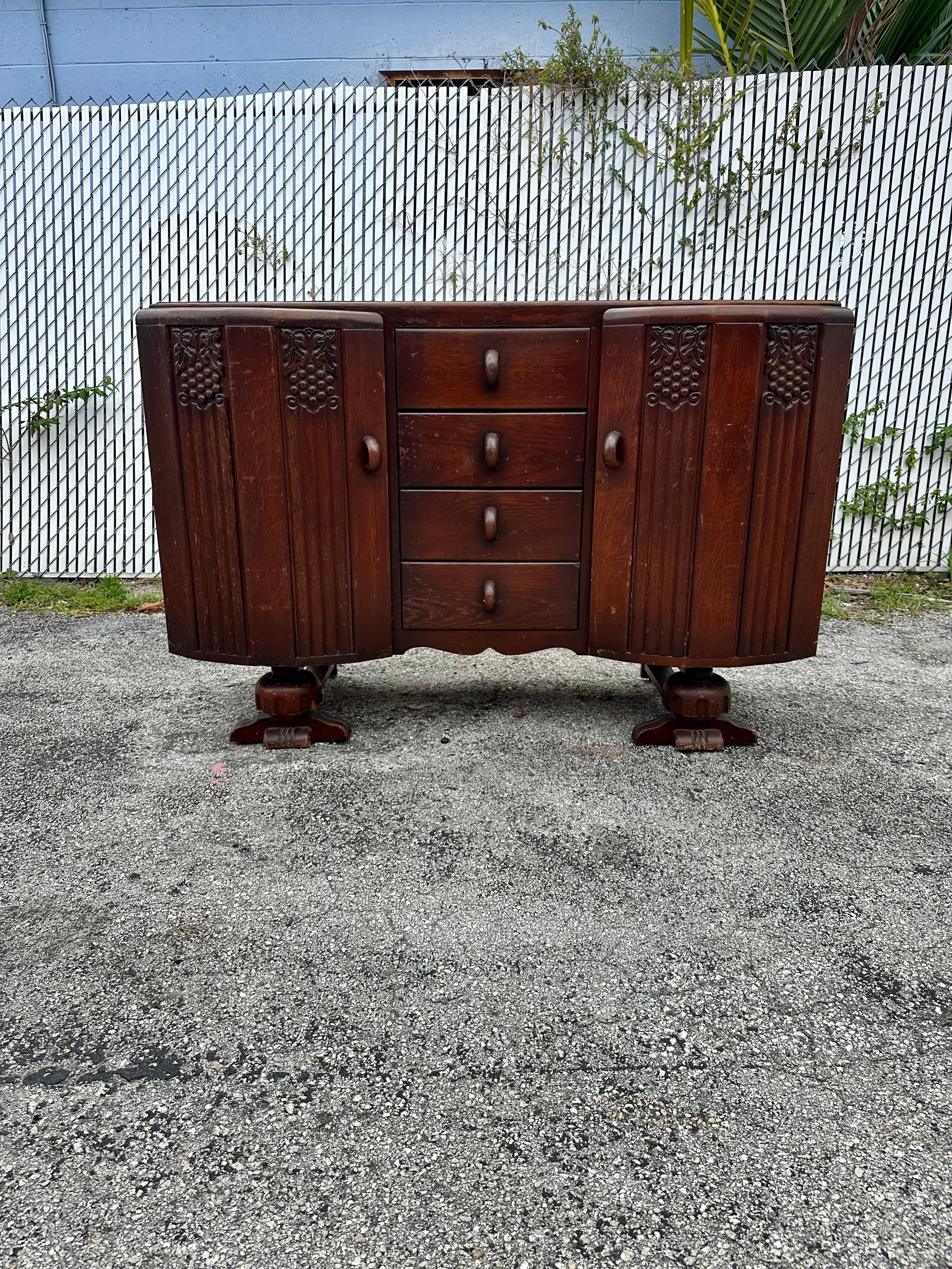 Versetzen Sie sich in das elegante und raffinierte frühe 20. Jahrhundert zurück mit diesem exquisiten, handgefertigten, geschnitzten Nussbaumschrank. Das äußerst seltene Sideboard vermittelt einen Hauch von Kultur und Raffinesse. Das Design ist