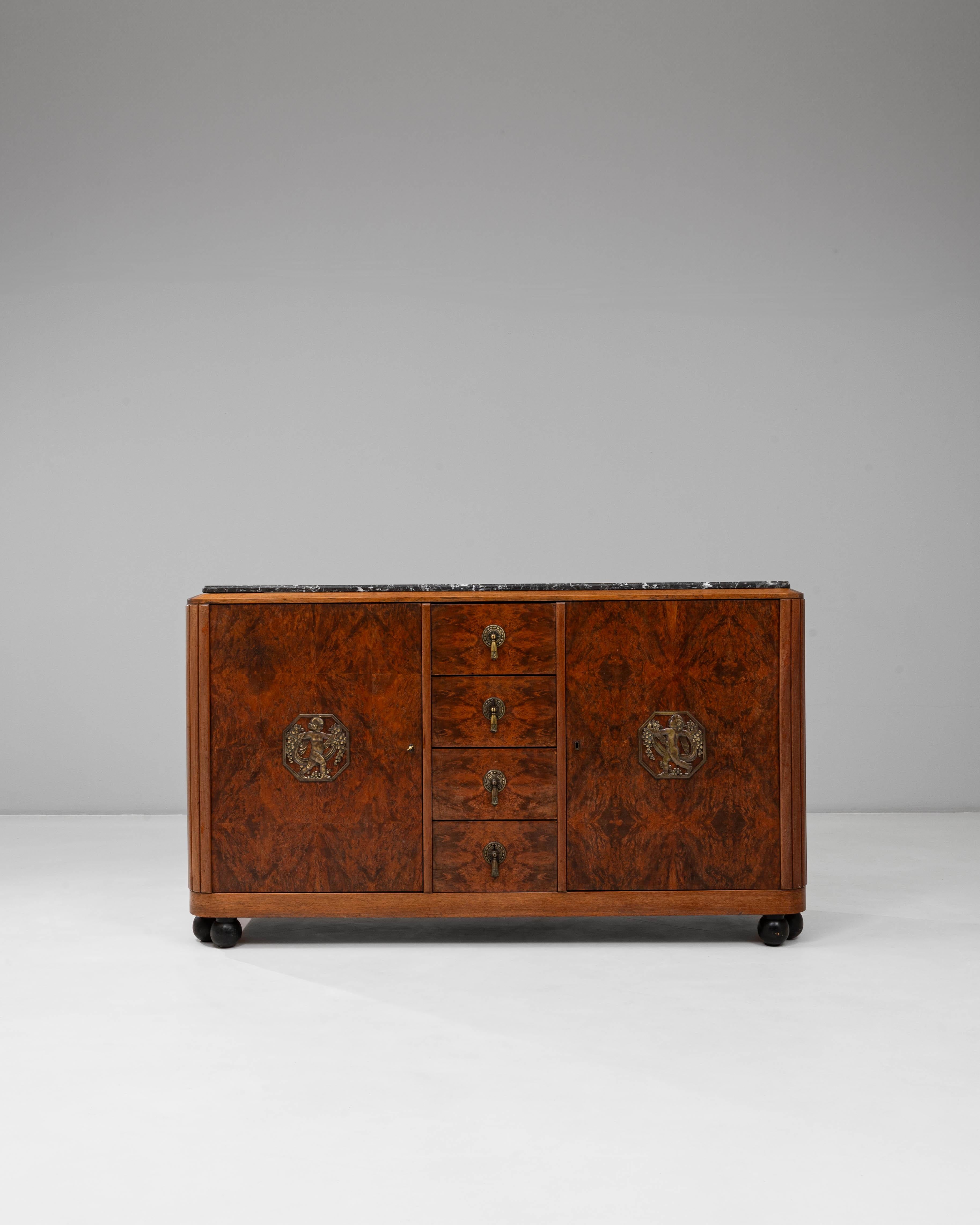 1920s Art Deco Wooden Sideboard with Marble Top. This refined Art Deco sideboard showcases the movement’s hallmark blend of elegance and geometric clarity, featuring richly figured wood veneers that create striking symmetrical patterns across the