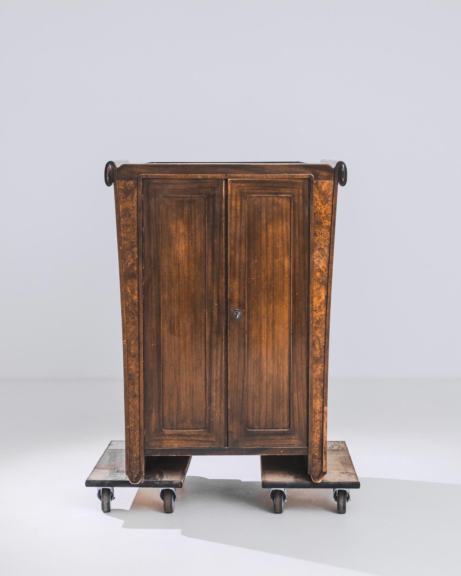 A hardwood cabinet from France, produced circa 1920. Worked to a high shine and with a robust silhouette that maintains the architectural angles of Art Nouveau, this bold cabinet drips opulence. Careful placement of rich wood grain draws the eyes up