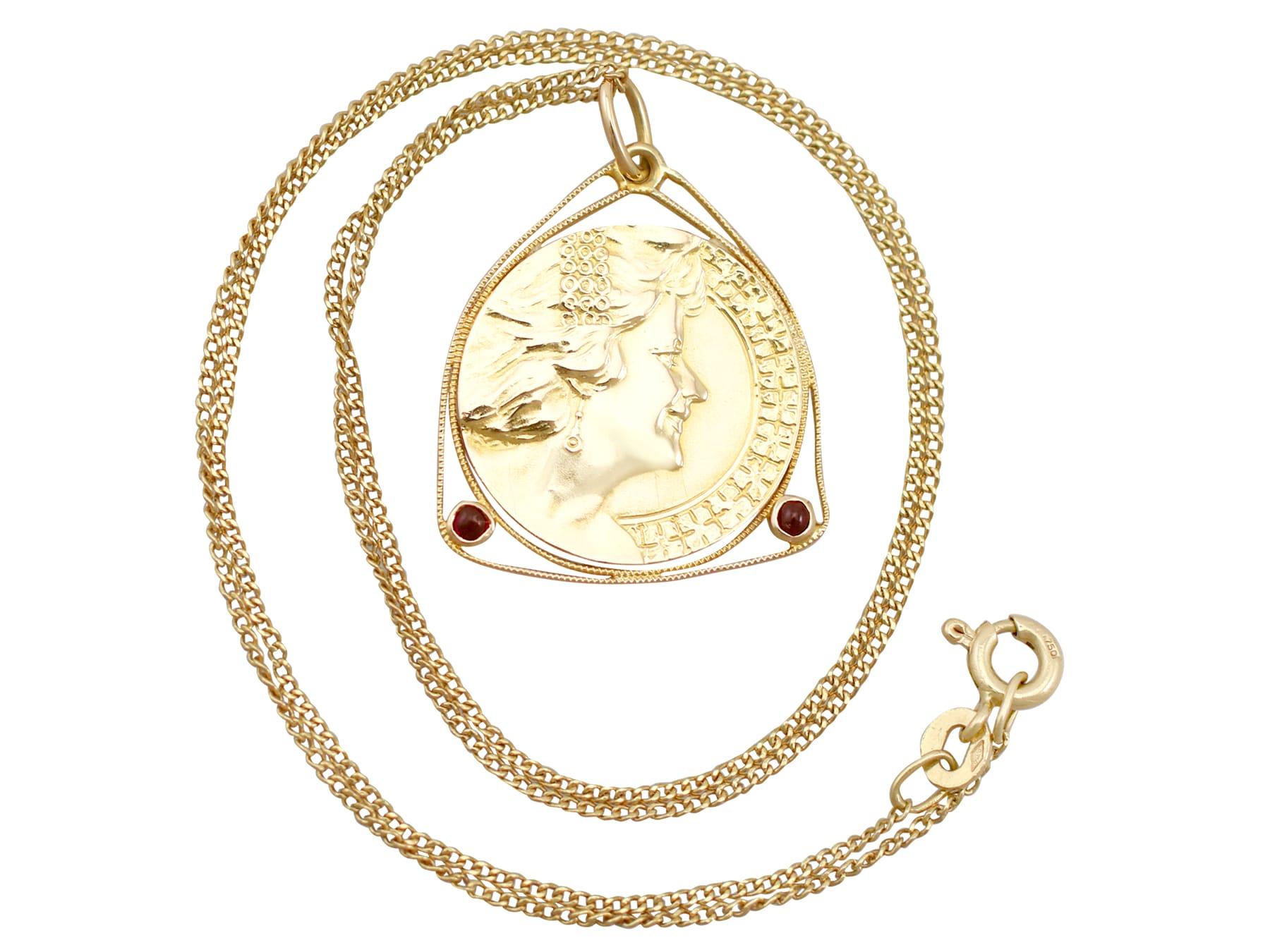 An impressive antique Art Nouveau 0.06 carat garnet and 18k yellow gold coin pendant; part of  diverse antique jewelry and estate jewelry collections.

This fine and impressive antique coin pendant has been crafted in 18k yellow gold.

The