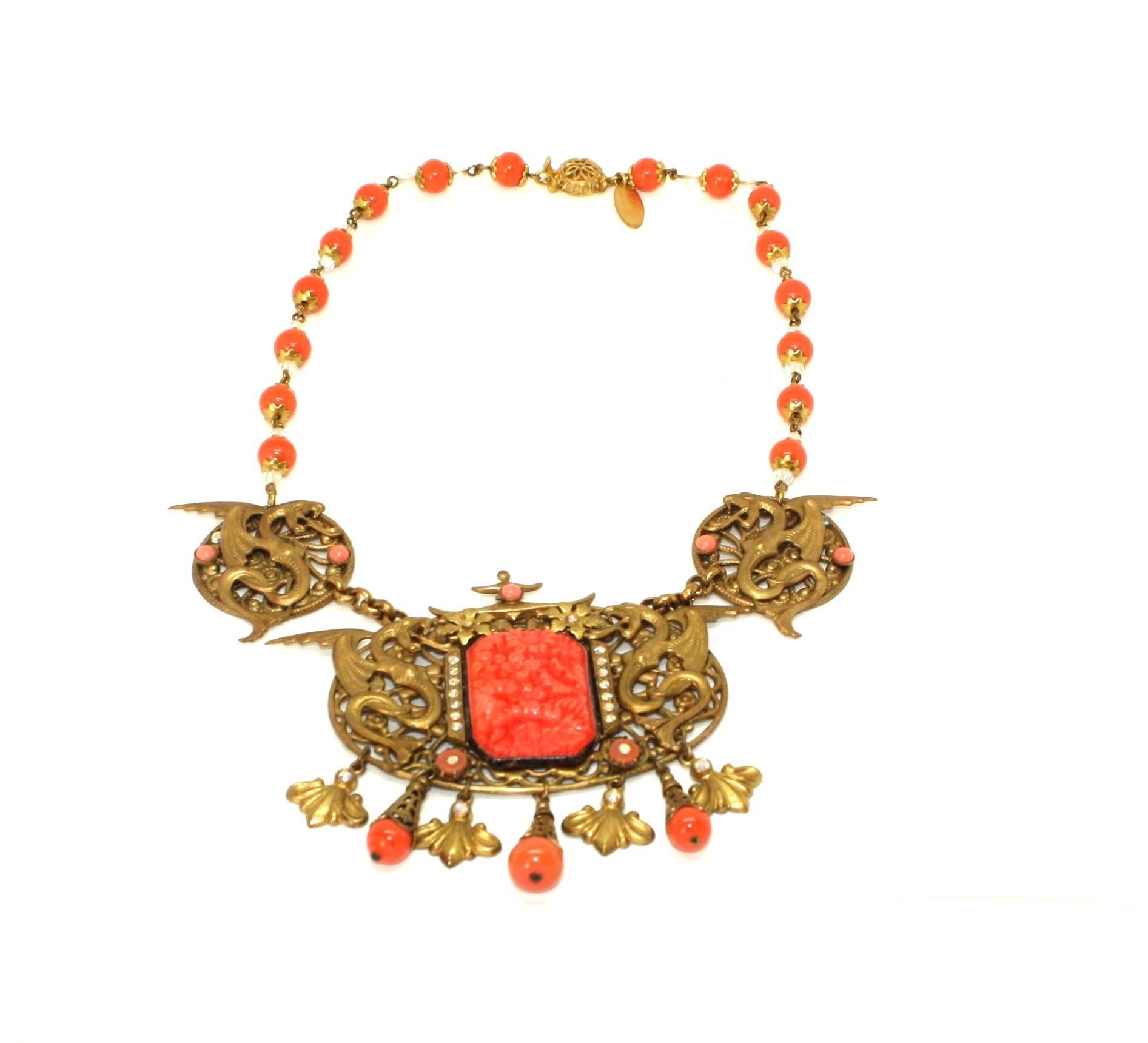 Stunning Bohemian Art Nouveau necklace from the 1920's featuring highly detailed dragon-adorned panels. There is so much beautiful detail in this necklace! It features a large filigree pendant with a large glass coral colour carved panel surrounded