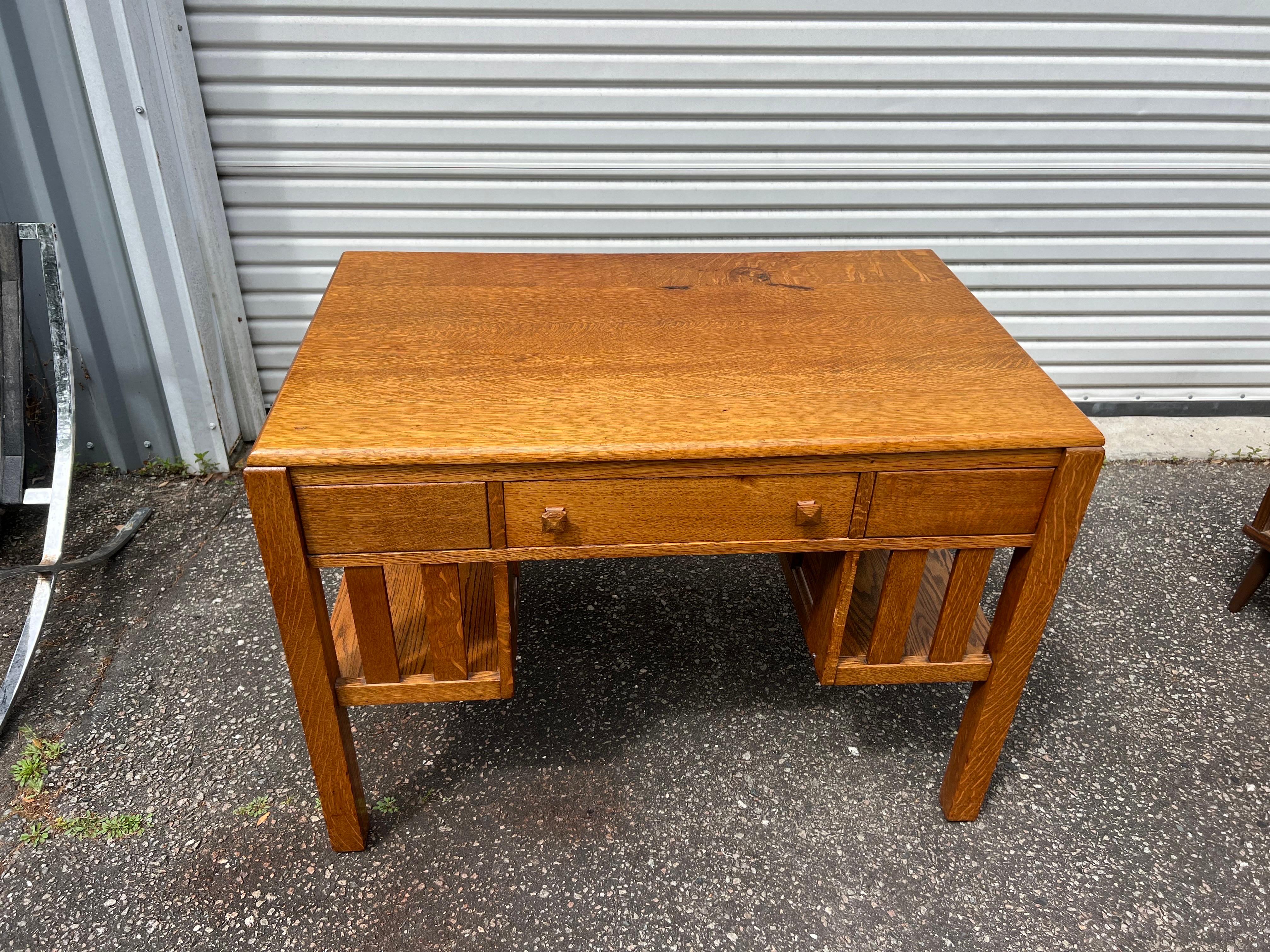 1920s Antique Stickley Style Quartersawn Oak Arts and Crafts Writing Desk With Built in Bookcase

A high-quality antique quartersawn oak arts and crafts writing desk or library table. Features the classic Stickley style and a single drawer with