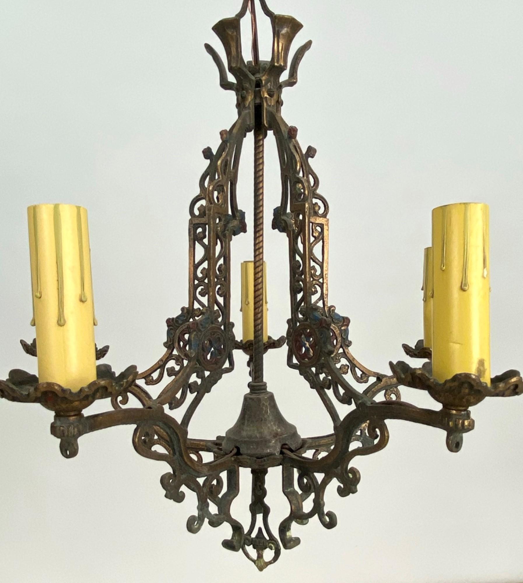 1920s Arts & Crafts style five arm bronze chandelier with original antique patina and original painted details. Also has the original matching canopy. Takes five household light bulbs. Adjustable pipe on canopy. This can be seen at our 400 Gilligan