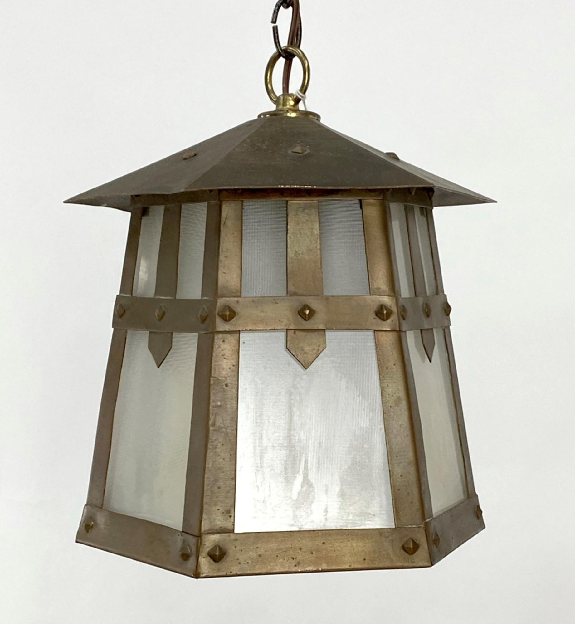 1920s brass Arts & Crafts hexagon shape lantern with opaque frosted glass. This has a single household socket. This can be seen at our 400 Gilligan St location in Scranton, PA.