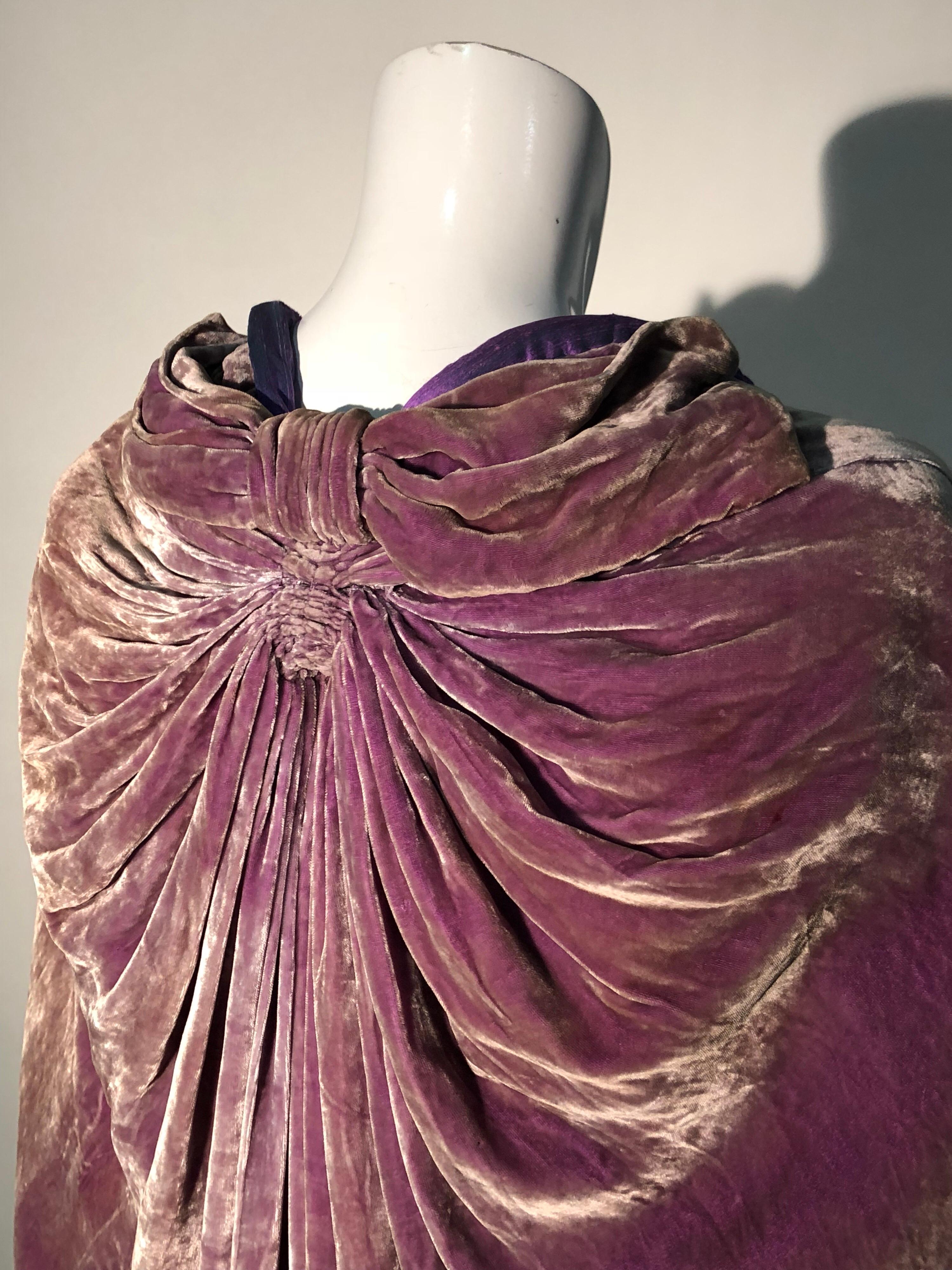 A beautifully redesigned 1920s aubergine silk velvet cocoon-style opera cape, redesigned and re-lined by Torso Creations. Edge of cocoon and armholes are edged in a kimono-inspired rolled and padded hem. Two large flat bow-shaped sections drape and