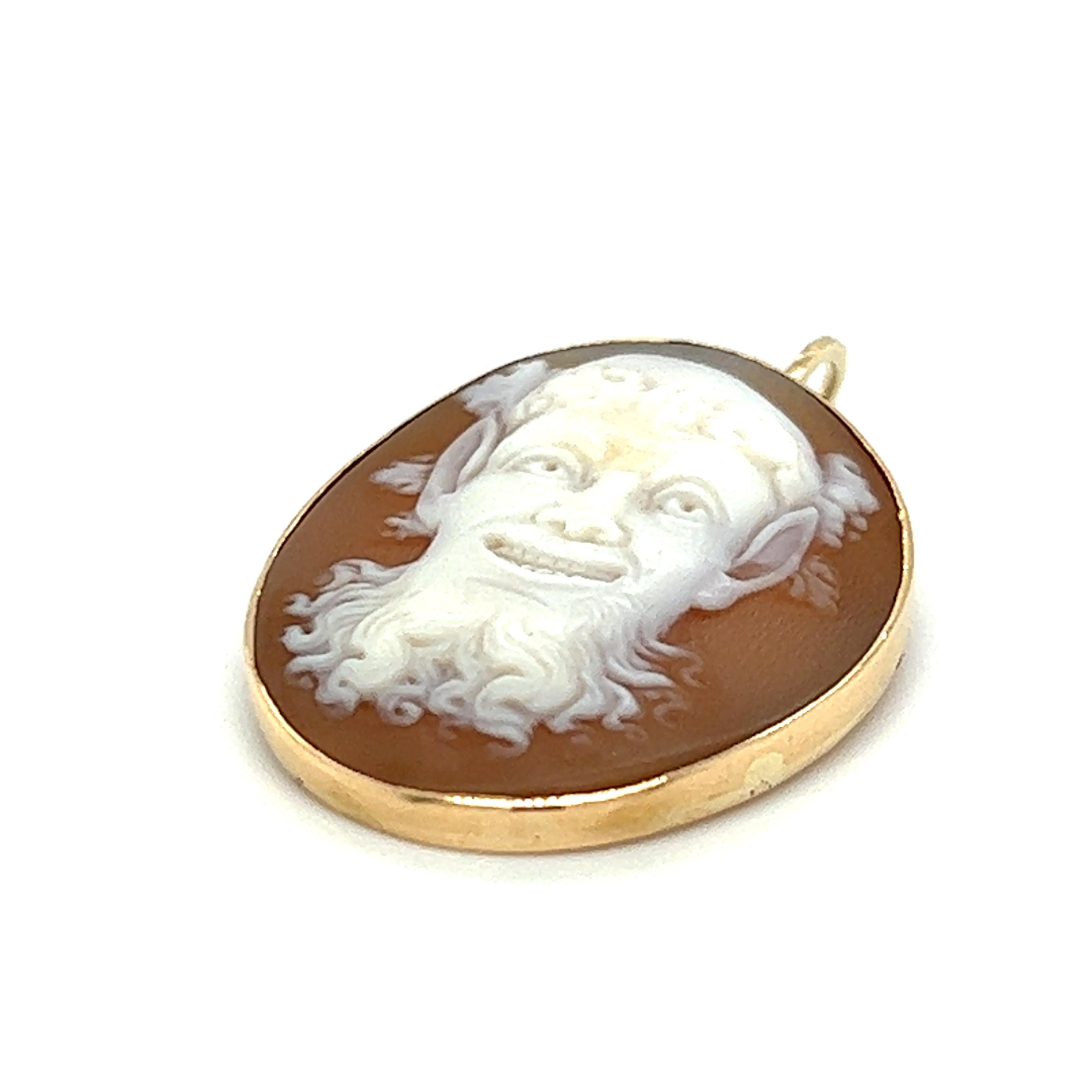 One 14-karat yellow gold shell cameo Bacchus design pendant.  The pendant measures 10.15mm long and 8.25mm wide.  