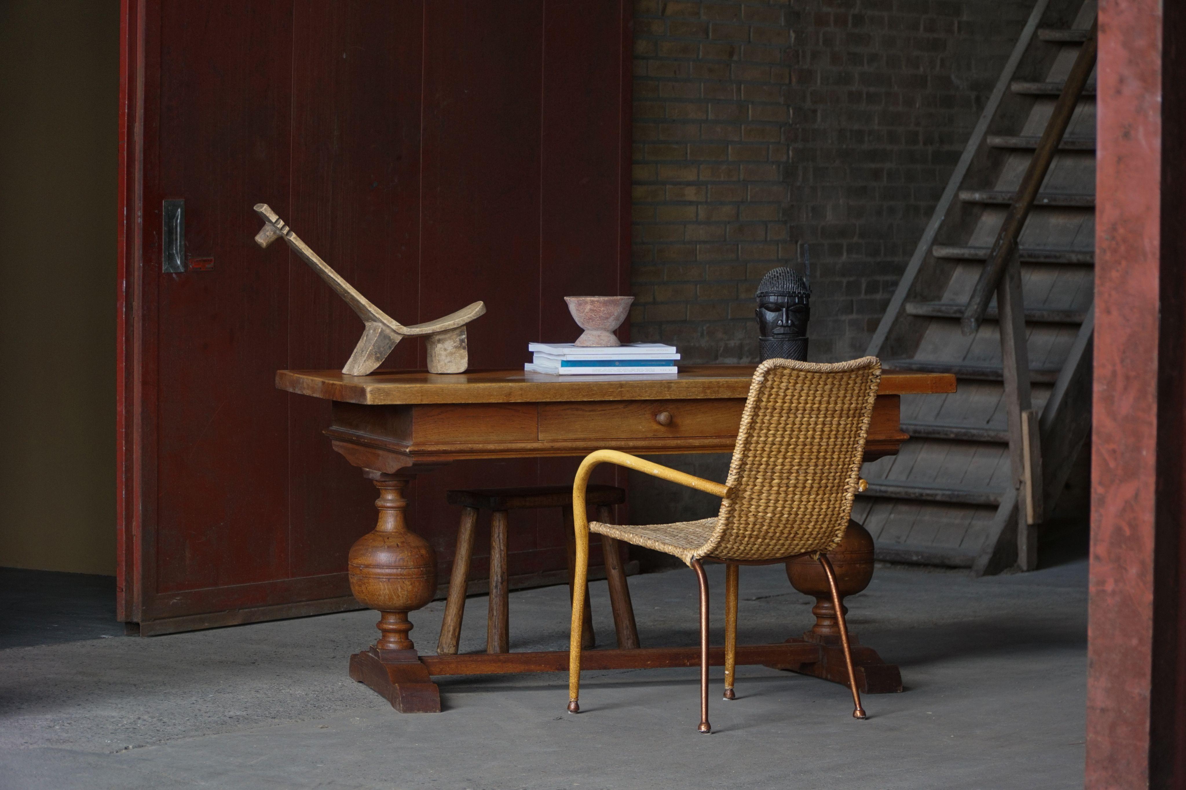 Un escritorio/mesa danés de la década de 1920, de hermosas proporciones, fabricado enteramente en roble macizo con una cálida pátina envejecida. La mesa presenta un tablero de formas finas sobre un cajón con carpintería de bella factura. 
Debajo,
