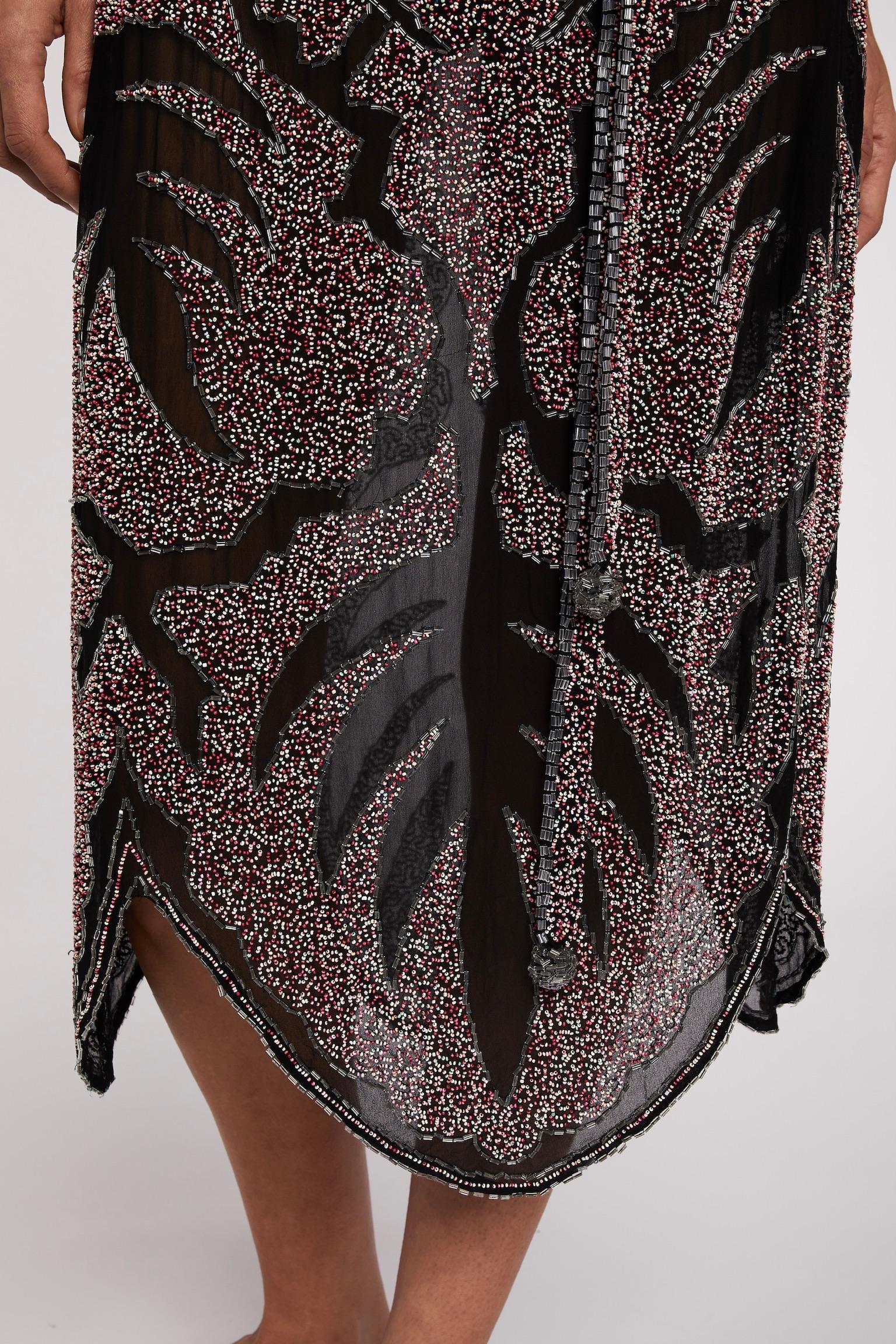 1920s flapper dress

- Intricate tutti frutti beading on black chiffon
-Beaded soft belt to create a flattering waist line 
- Excellent condition 
- Sold by Mae Vintage London