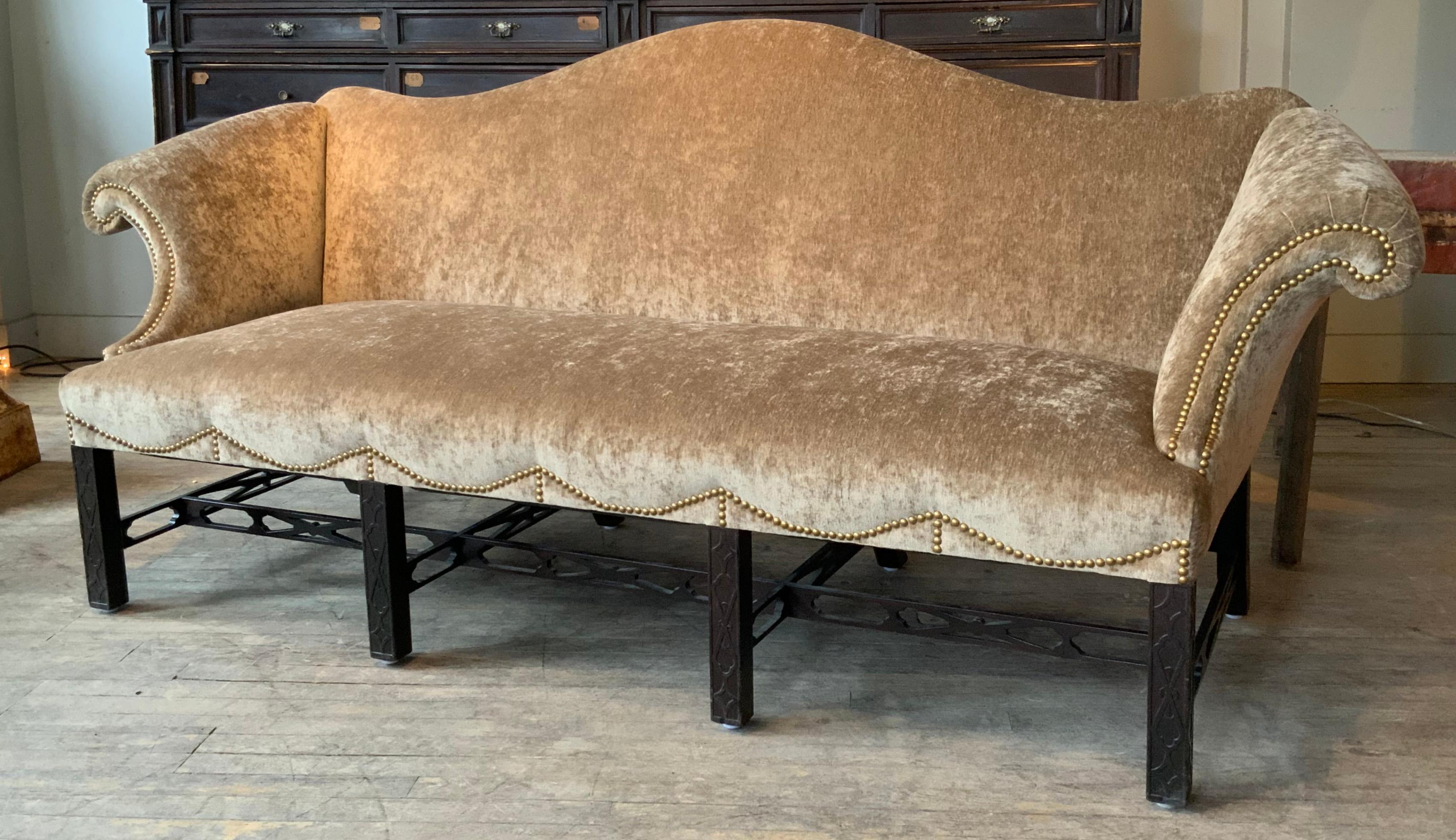 A beautiful 1920s Camelback sofa, just reupholstered in an elegant Beige cut velvet. the sofa has wonderful curved arms and a graceful camelback shape. the base is detailed in a Classic Chinese Chippendale style, with open fretwork stretchers.
