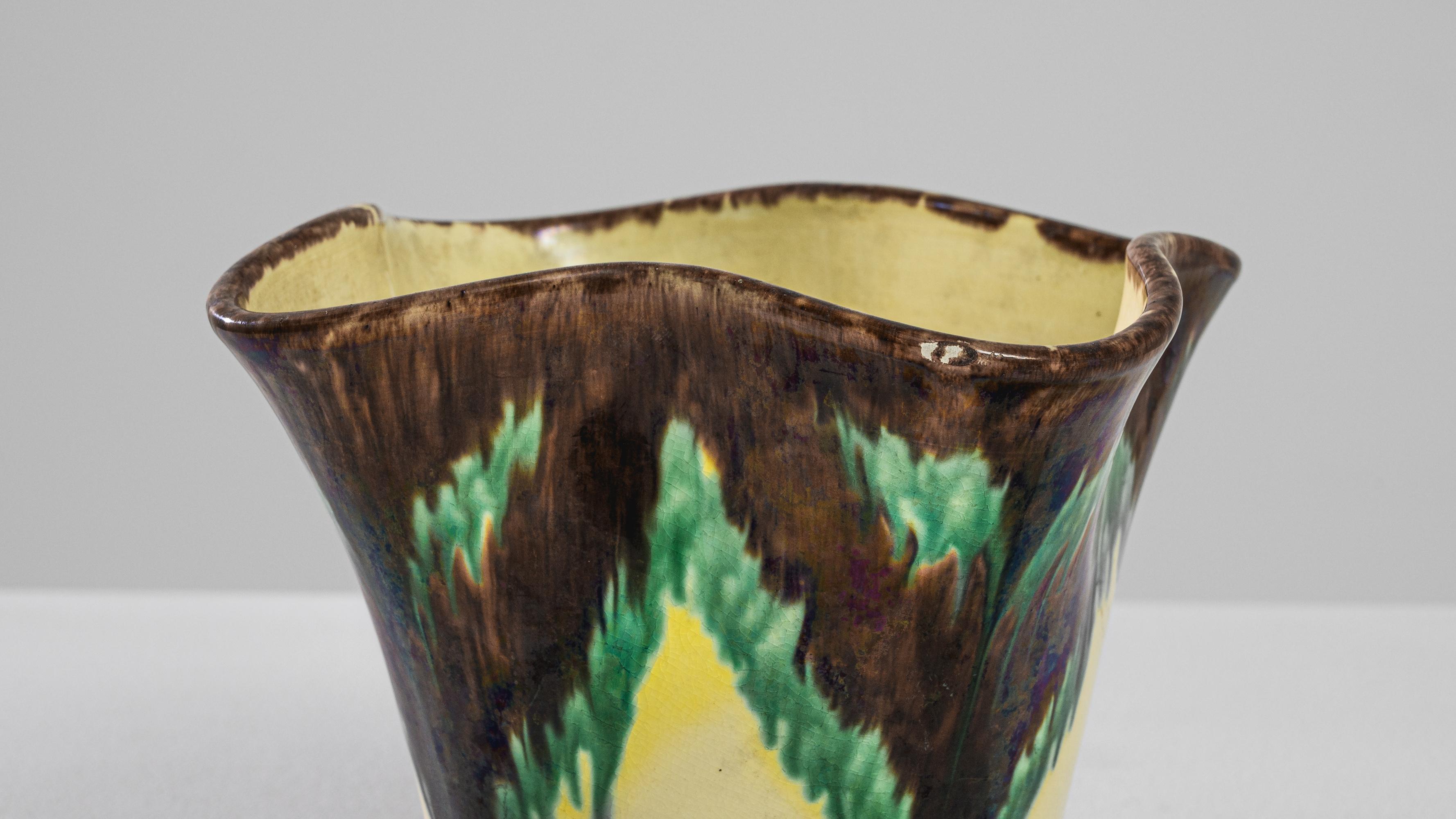 This 1920s Belgian Ceramic Planter is a remarkable relic of the Art Deco era, notable for its geometric shape and contrasting color palette. Crafted from quality ceramics, it features a striking flared rim that adds an element of drama to its form.