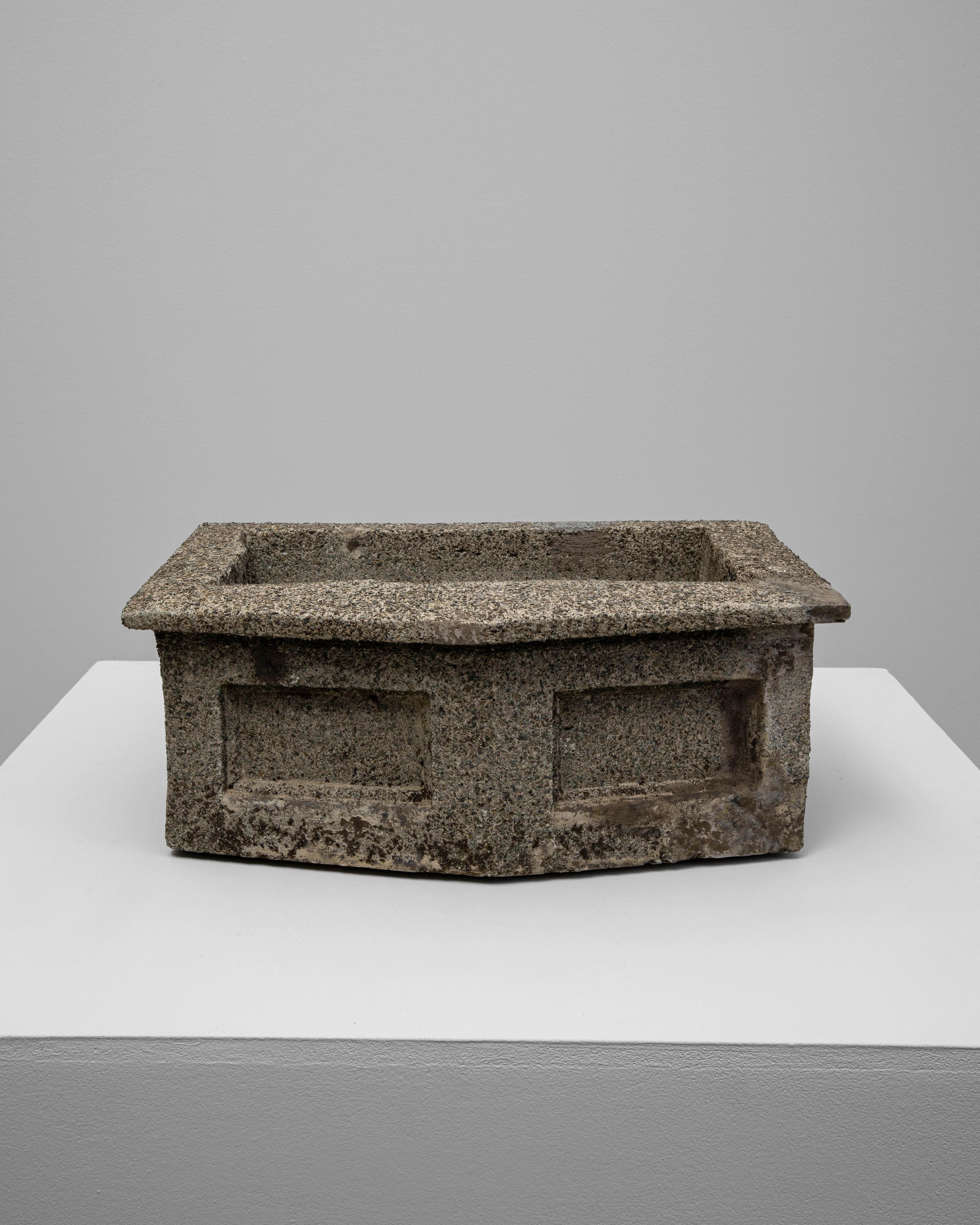 This 1920s Belgian concrete sink features a sturdy rectangular form with paneled detailing and a beautifully weathered surface that highlights decades of use and natural patina. Crafted from solid concrete, it embodies the utilitarian charm and
