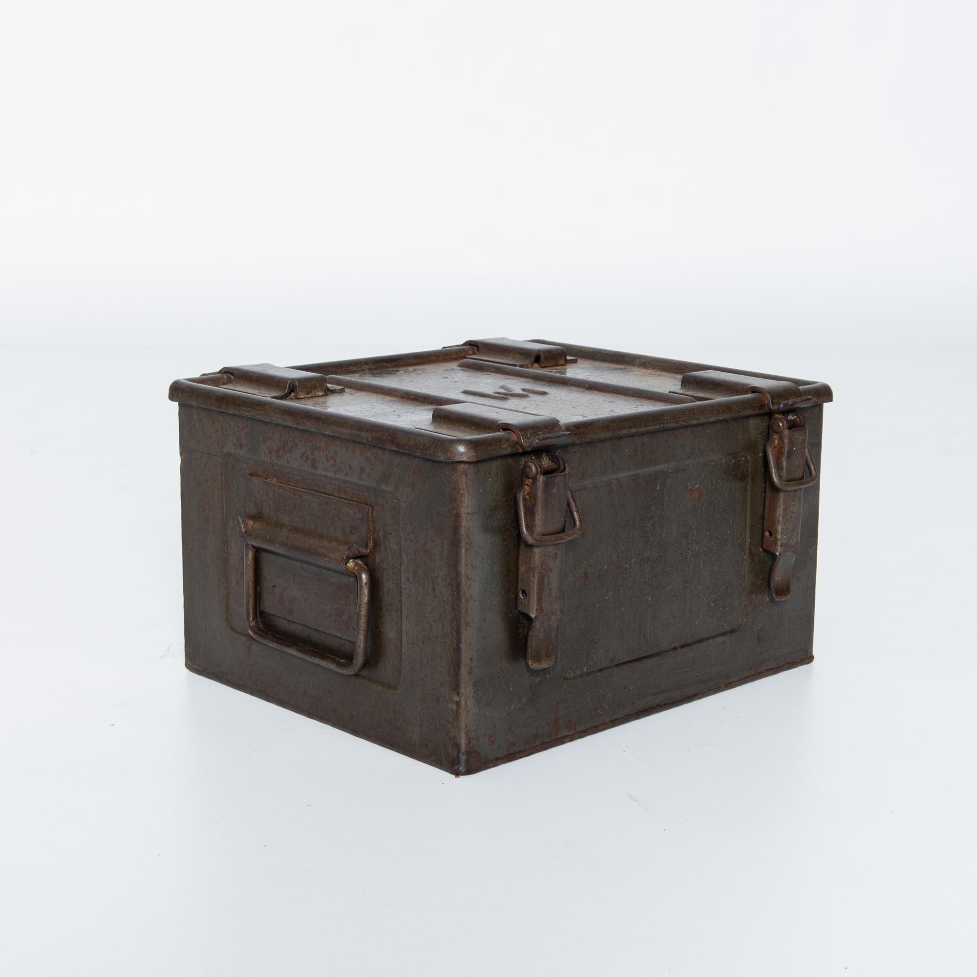 Cette boîte en métal belge des années 1920 est une véritable relique du passé, offrant un aperçu de l'histoire des objets du quotidien. Sa construction robuste évoque une époque où la durabilité était primordiale, et sa surface usée par les