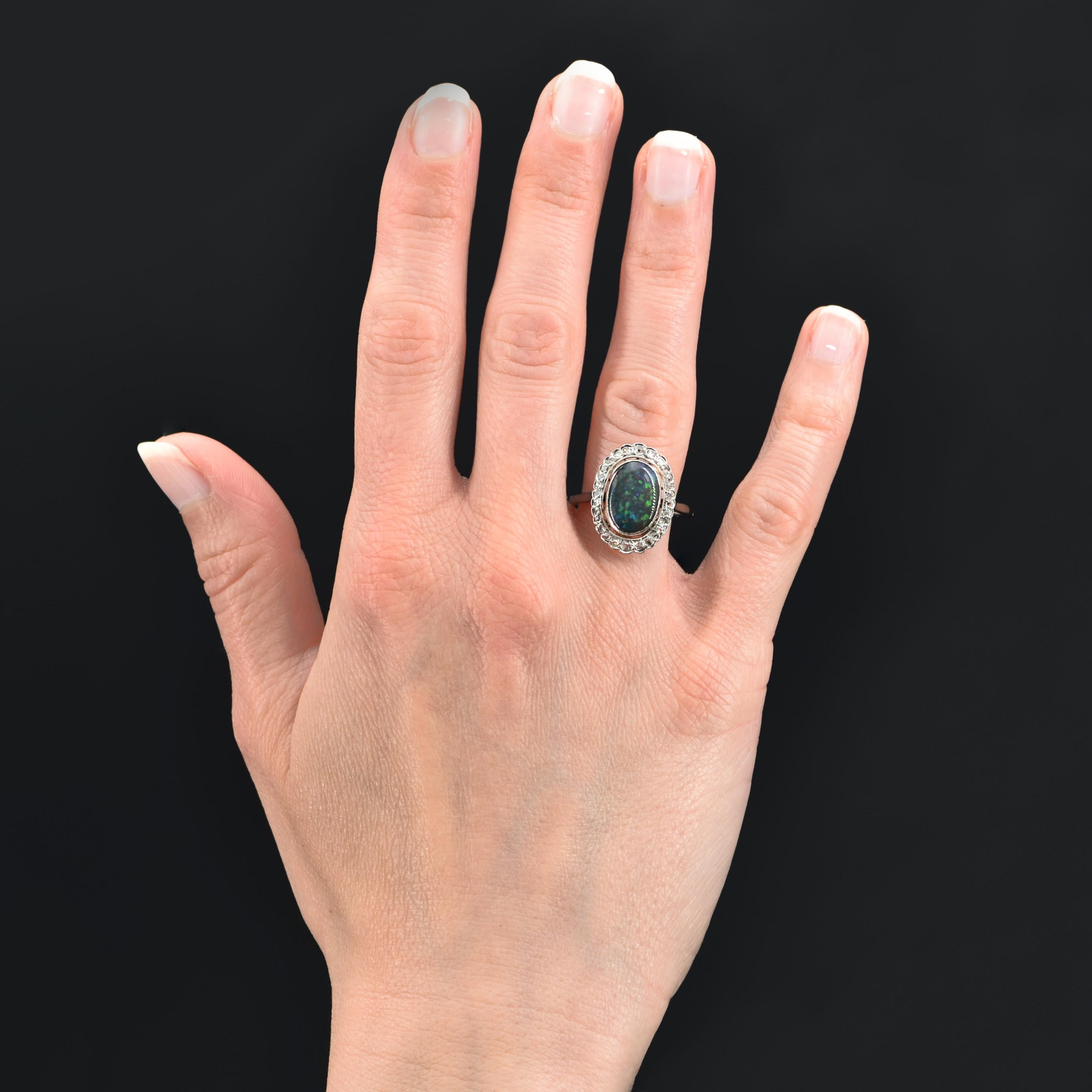 Ring in platinum.
Magnificent marquise ring it is decorated in the center of a black opal in millegrain closed setting in a surround of rose-cut diamonds. The setting is scalloped and the basket openwork to let the light penetrate under the
