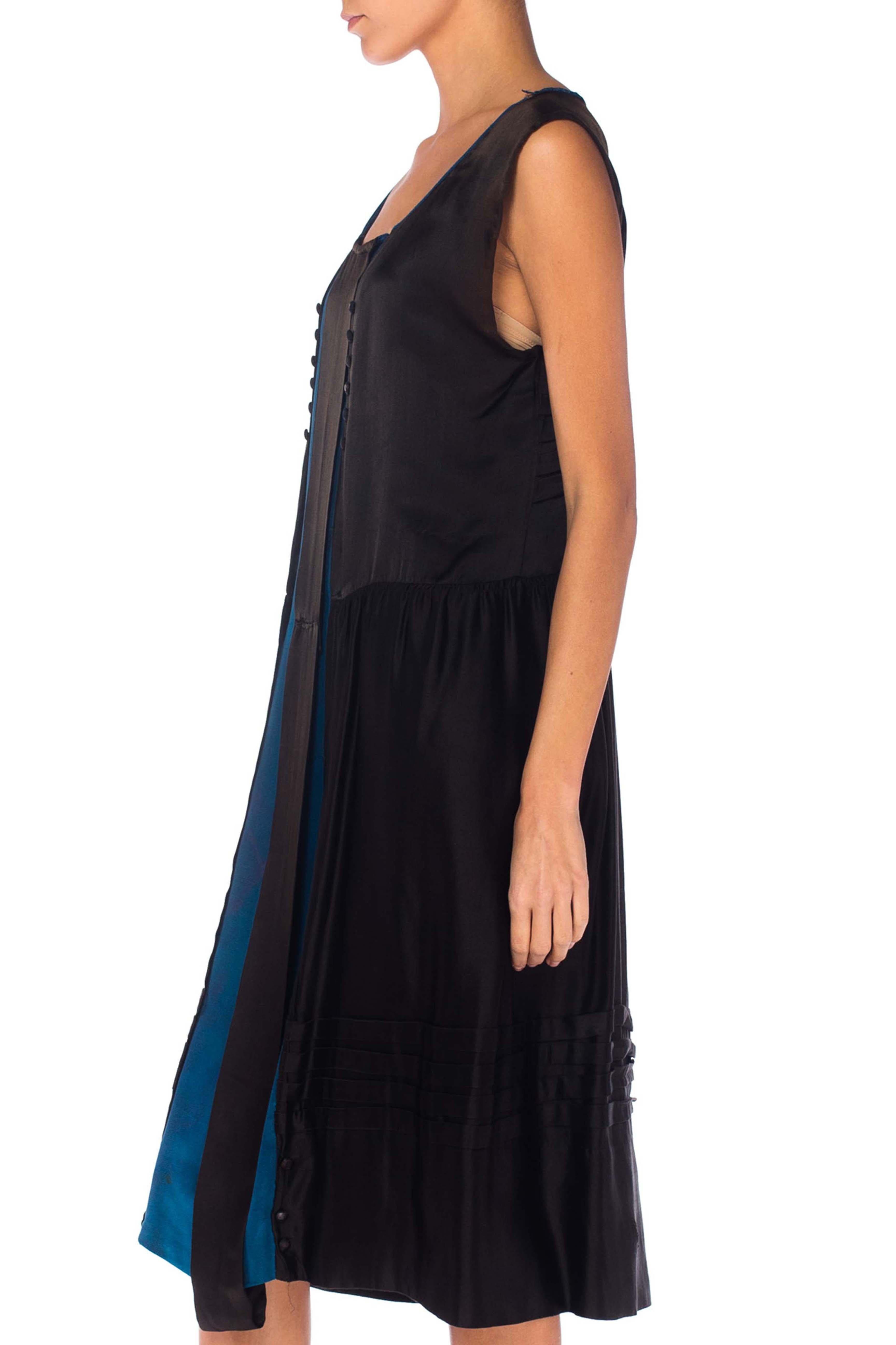Areas of wear and subtle discoloration. Overall strong and wearable condition. Priced as-is 1920S Black Silk Satin Straight Cut Modern Flapper Dress With Bright Blue Inset Panel 