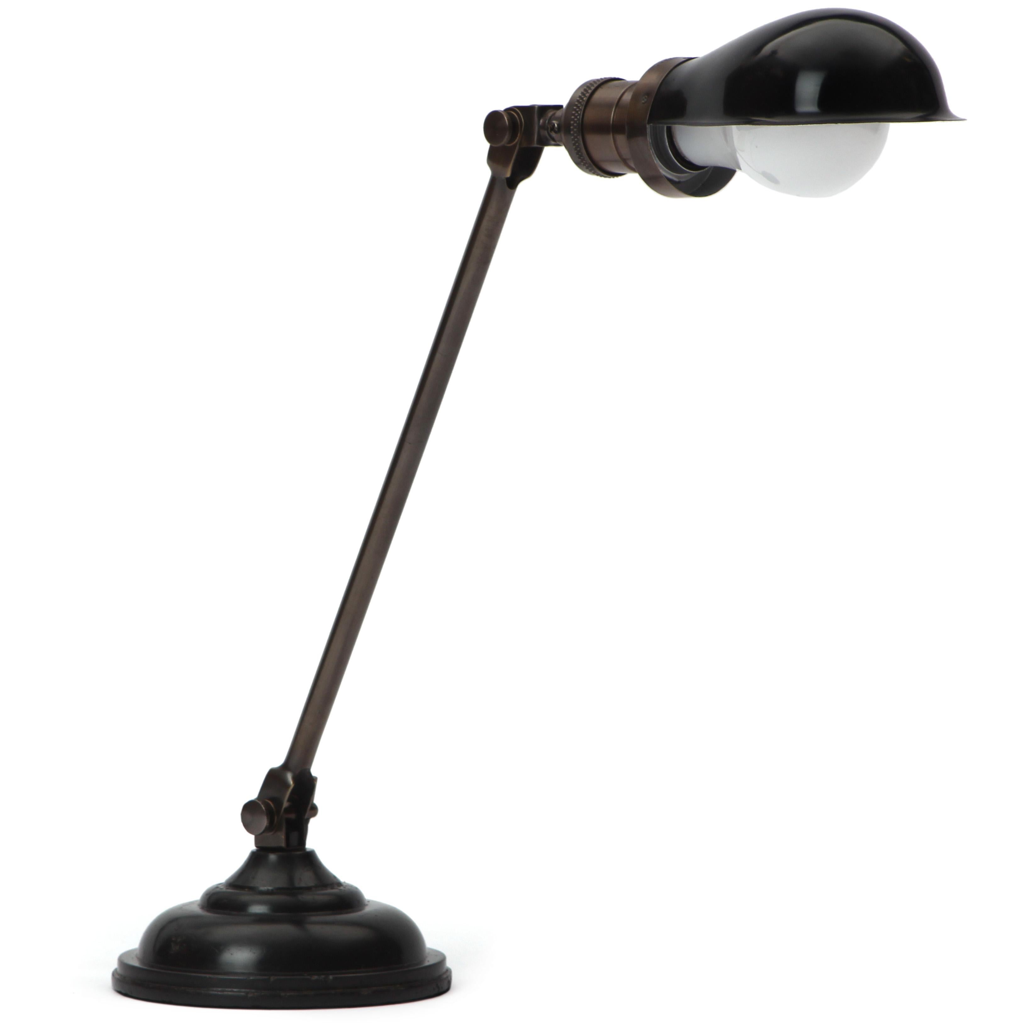 An adjustable and articulated industrial desk lamp patinated in black with a stepped base, swivelling avocado shaped hood and exposed tension bars. Manufactured in the USA circa 1920s.