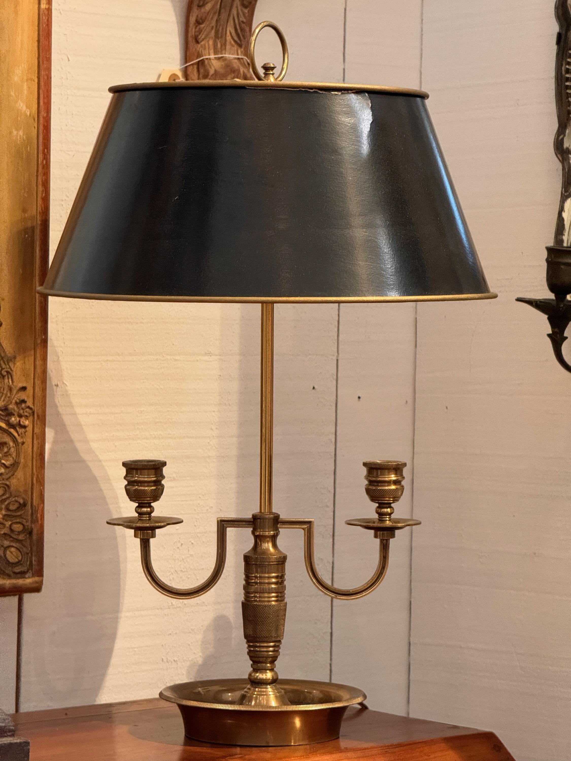 A brass bouillotte lamp with a paper shade. Double arms for candles.