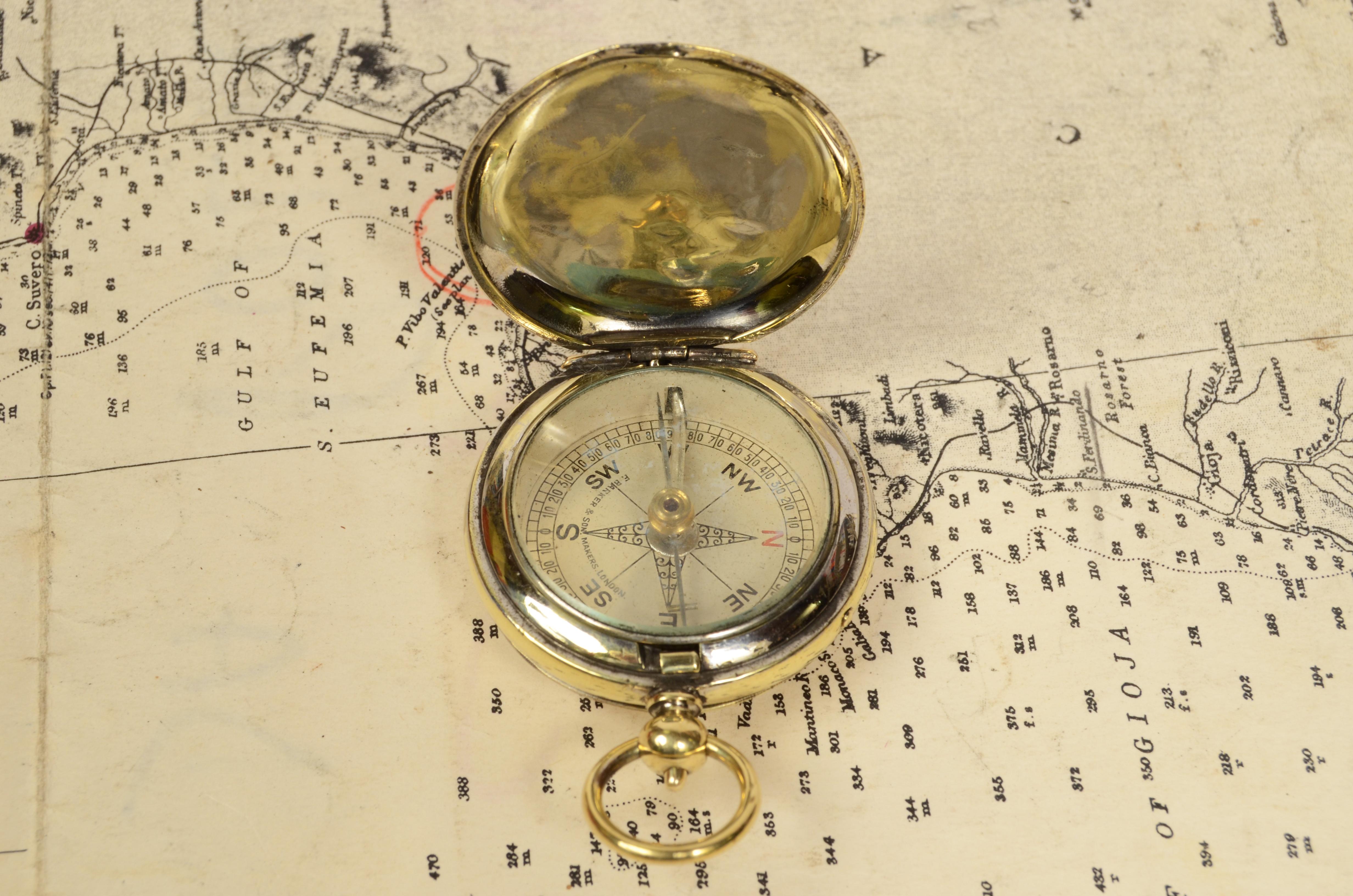 1920s Brass pocket compass in the shape of a pocket watch, and equipped with a lid with snap closure with release button inside the ring. Four-winds compass card complete with goniometric circle for calculating horizontal angles. Good condition,