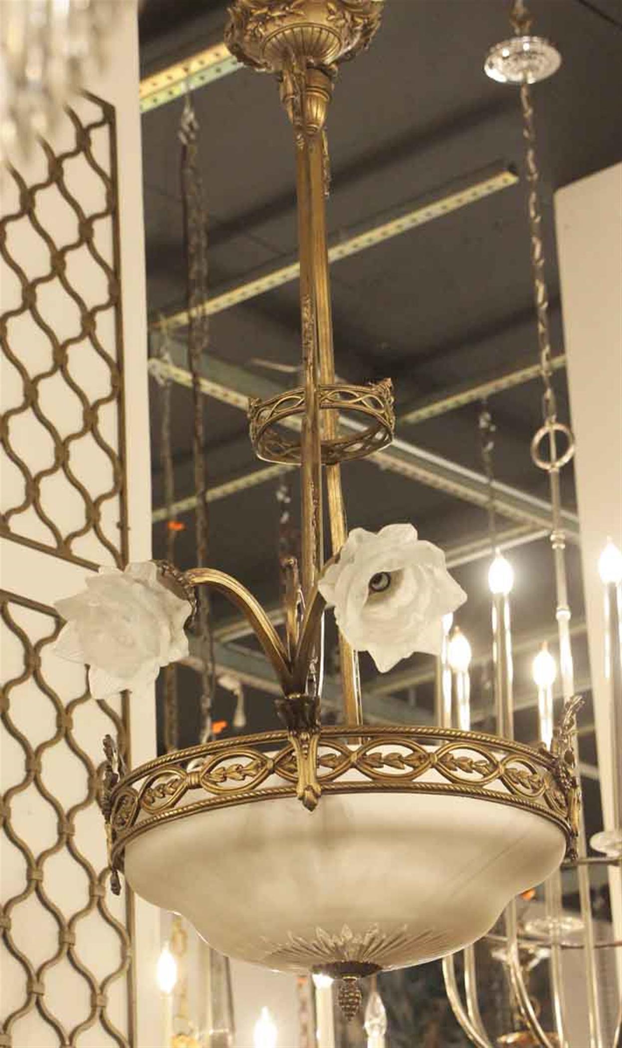 1920s bronze and glass dome shaped pendant light with four floral frosted glass shades and decorative leaf and floral detail. This can be seen at our 2420 Broadway location on the upper west side in Manhattan.