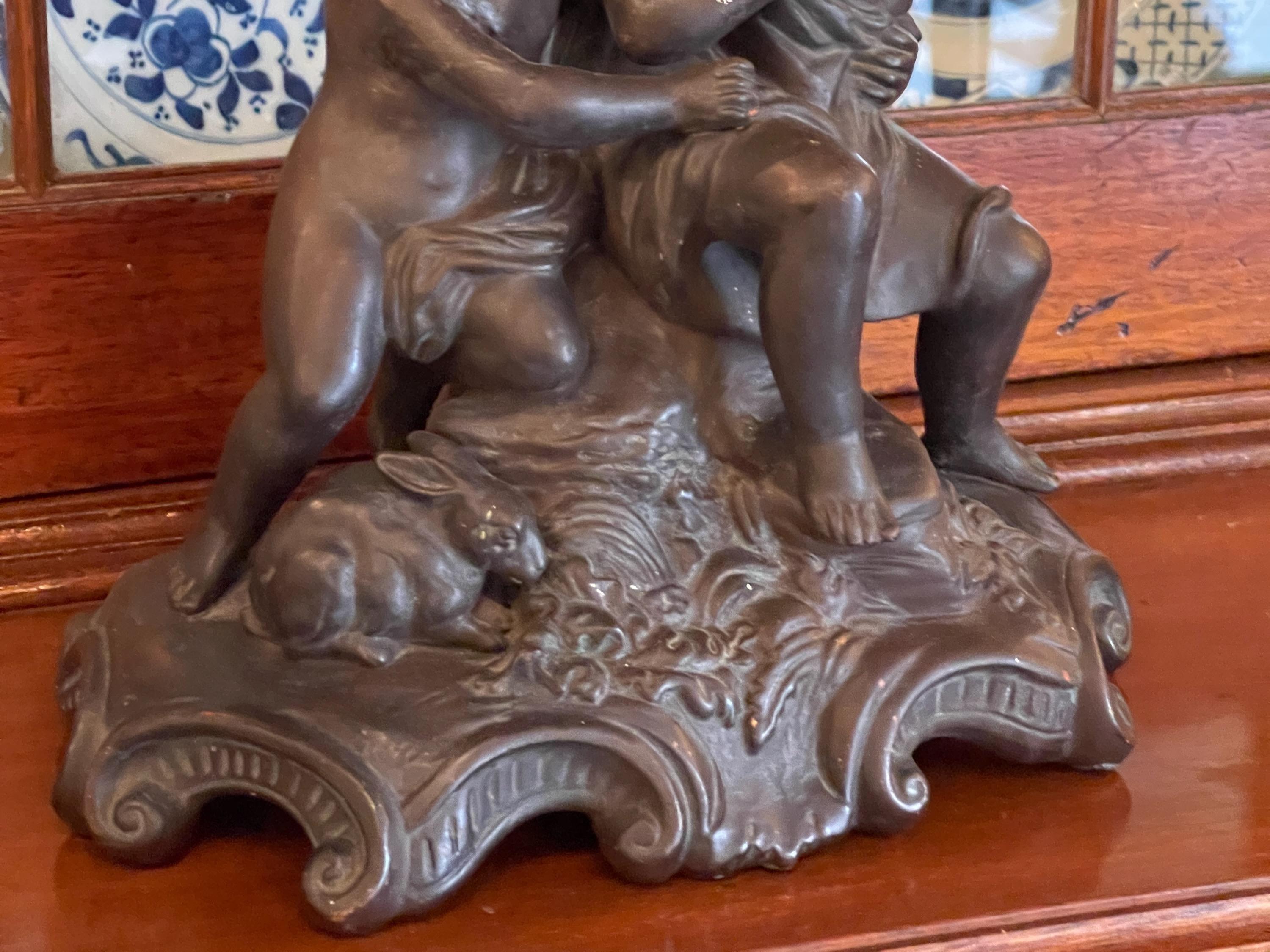 Two children with two rabbits . Bronze color