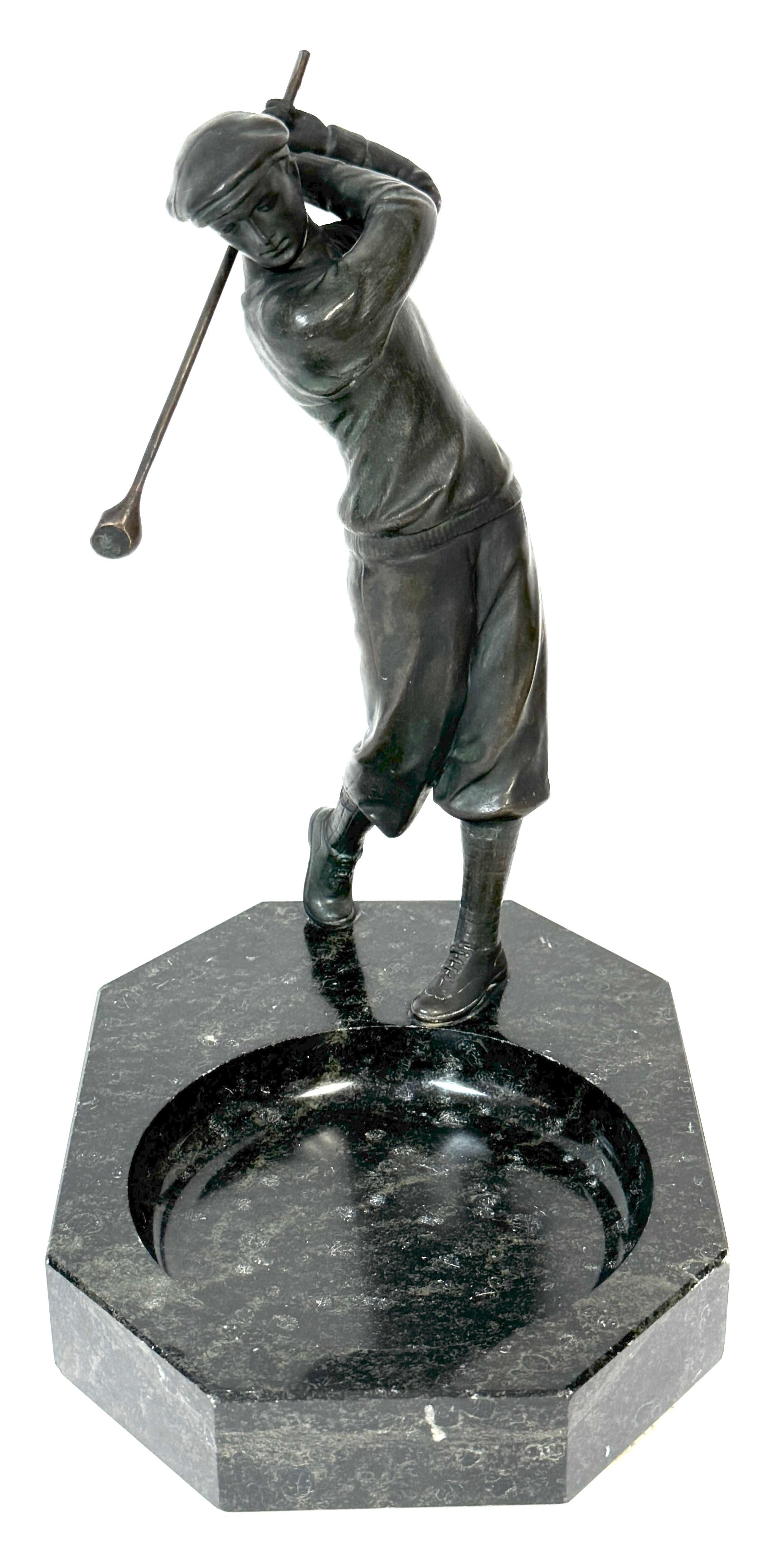 1920s Bronzed Swinging Golfer & Marble Catch All/Vide-Poche

France, Circa 1920s 

This finely made 1920s French bronzed metal sculpture captures the elegance and precision of a golfer in mid-swing. Dressed in period attire, including knickerbocker