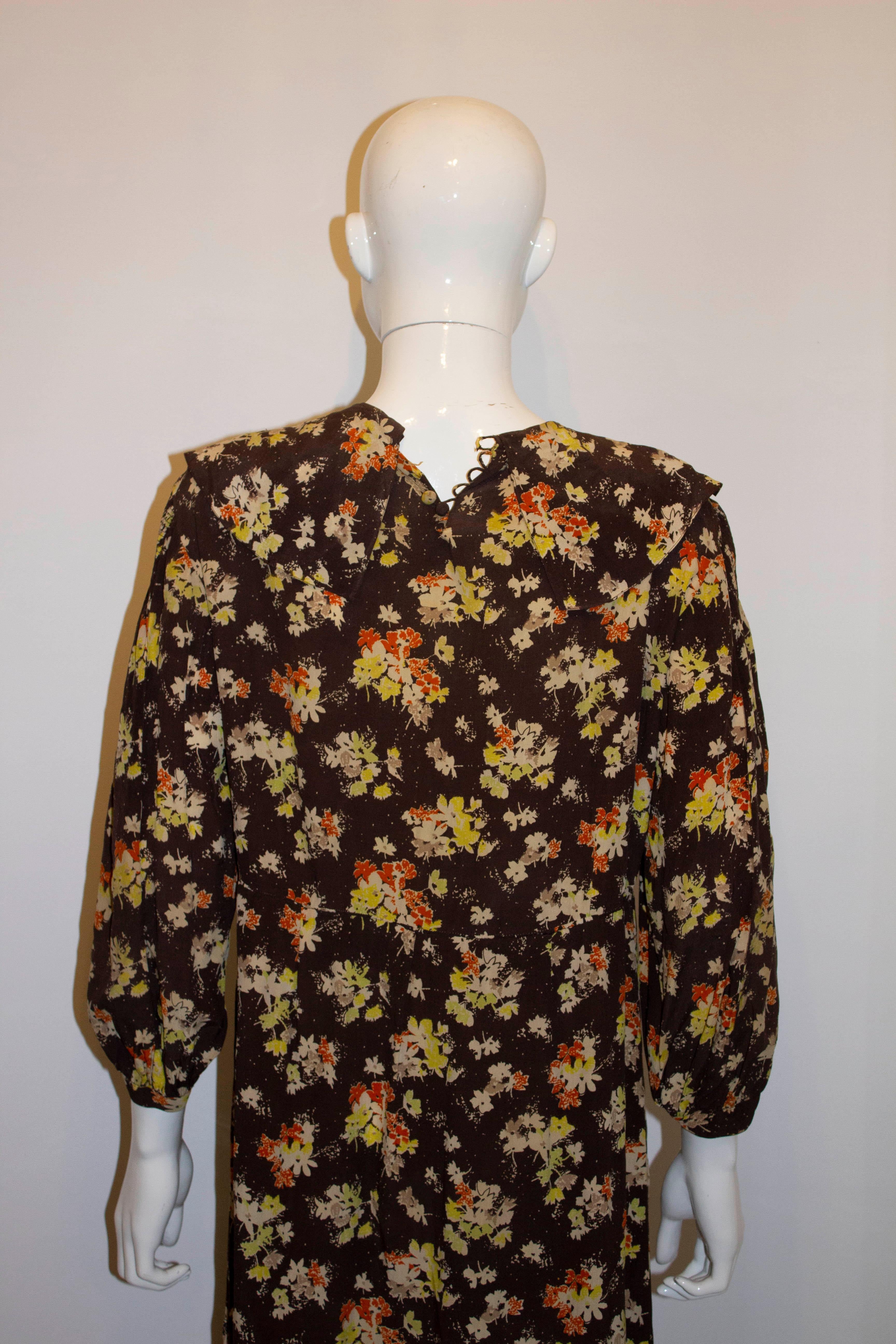 A pretty and easy to wear vintage  silk dress from the 1920s. The dress has a button opening at the back, gathering on the lower skirt and shoulders, and is in pretty brown, yellow and orange print. Measurements: Bust up to 40'', length 46''