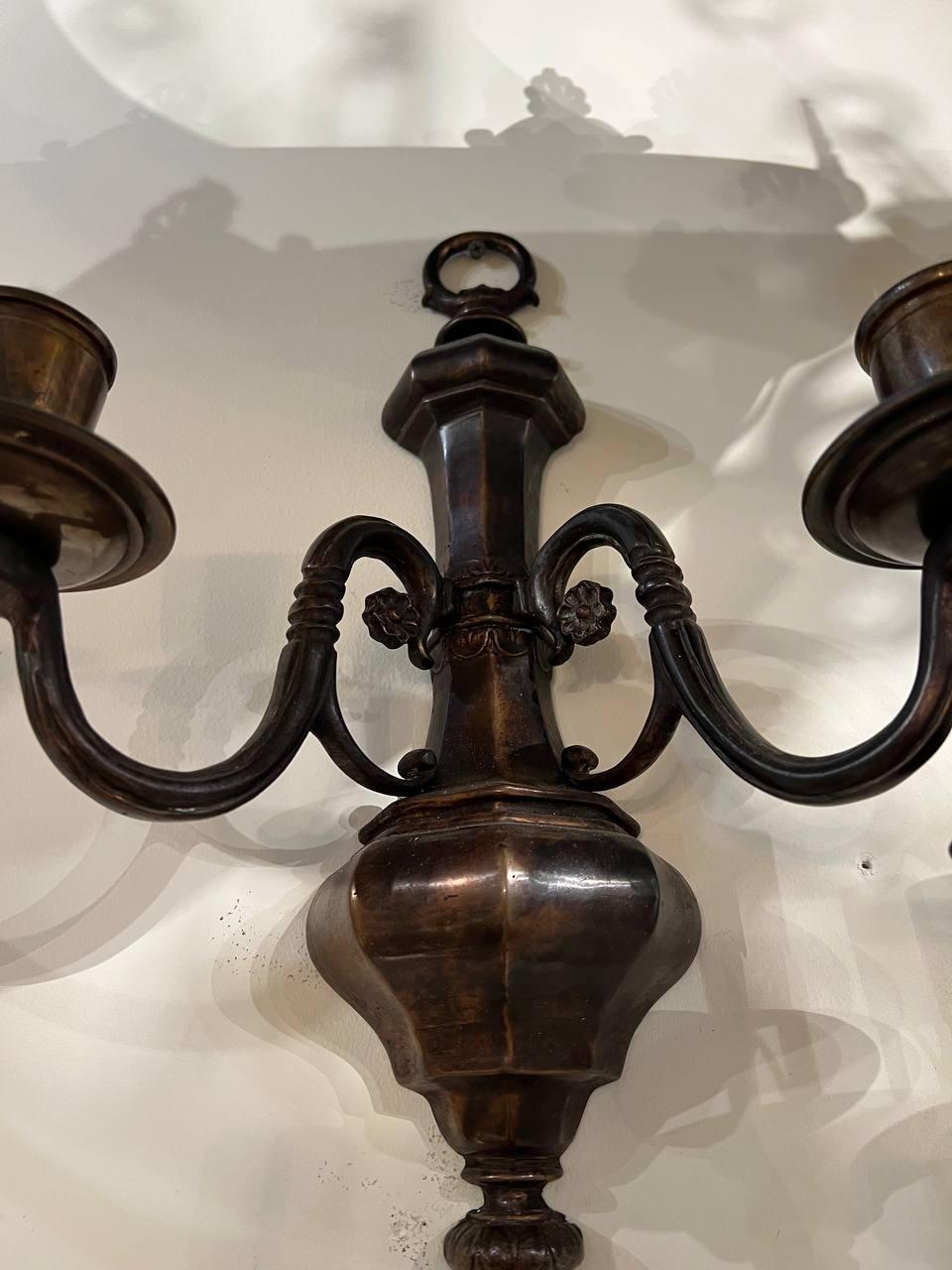 A pair of circa 1920’s Caldwell sconces with brown patina.