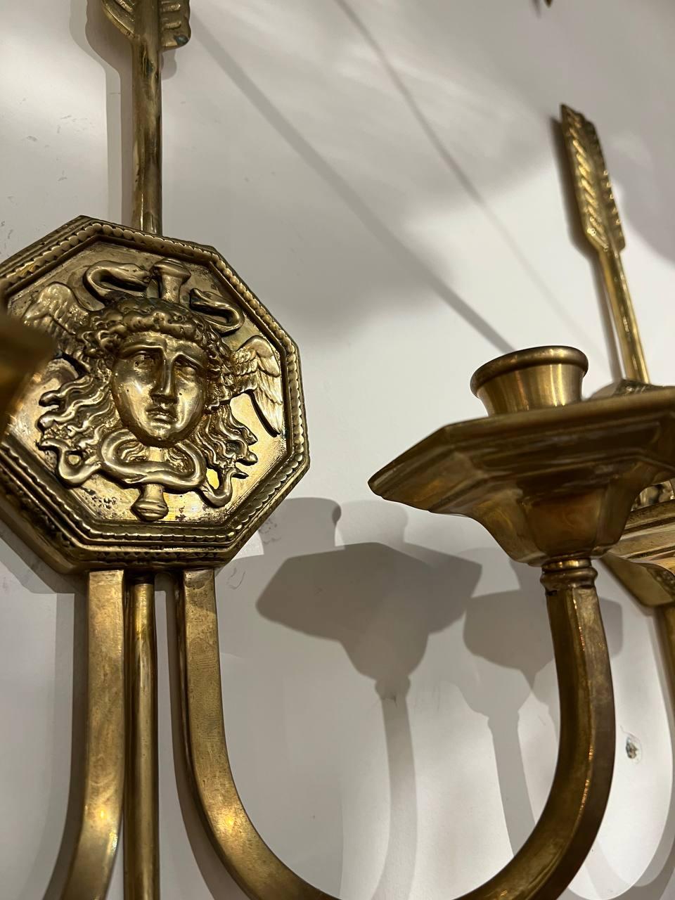 A pair of circa 1920’s sconces with medusa head and arrow design. Two lights