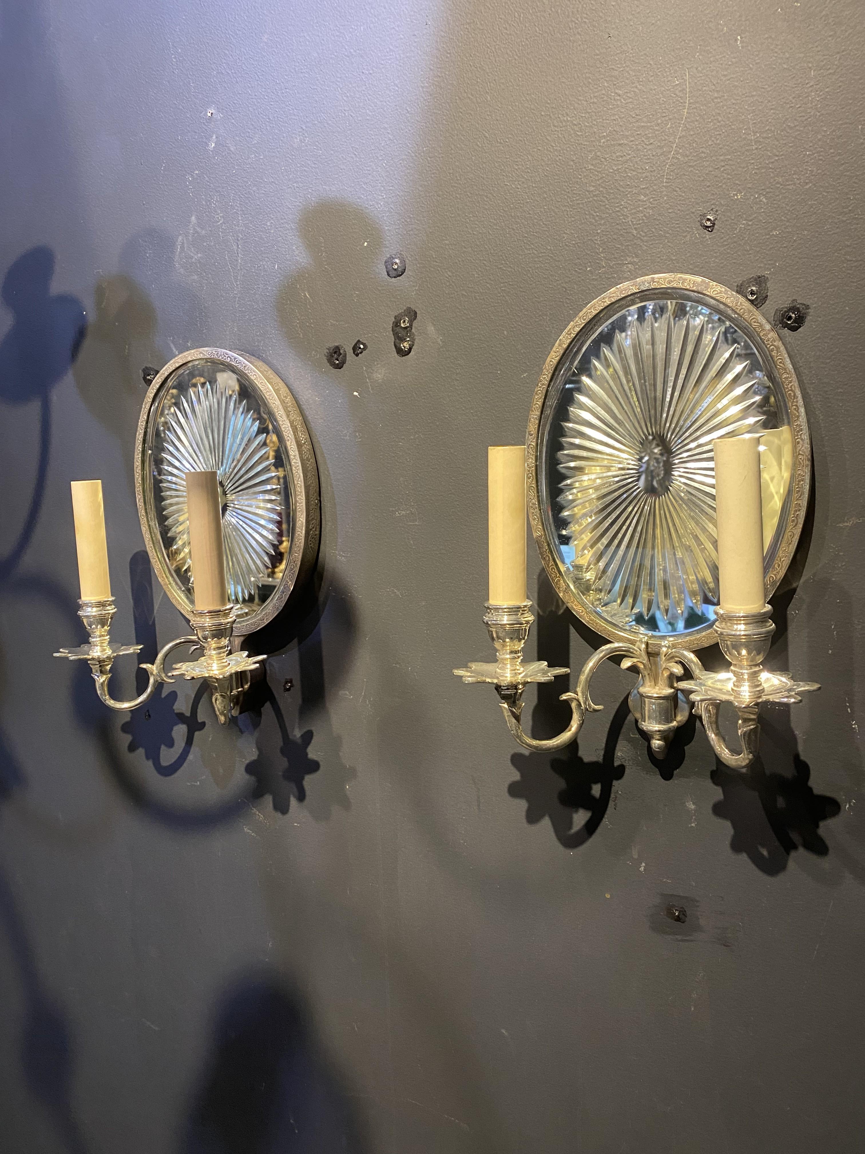 A pair of circa 1920’s Caldwell etched mirrored sconces with silver plated arms for two lights