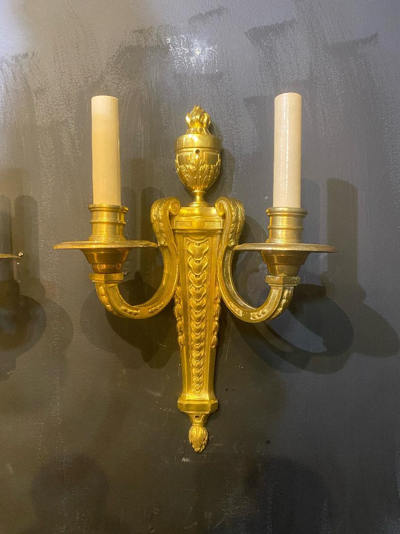 A pair of circa 1920's gilt bronze sconces with neoclassic design and two lights