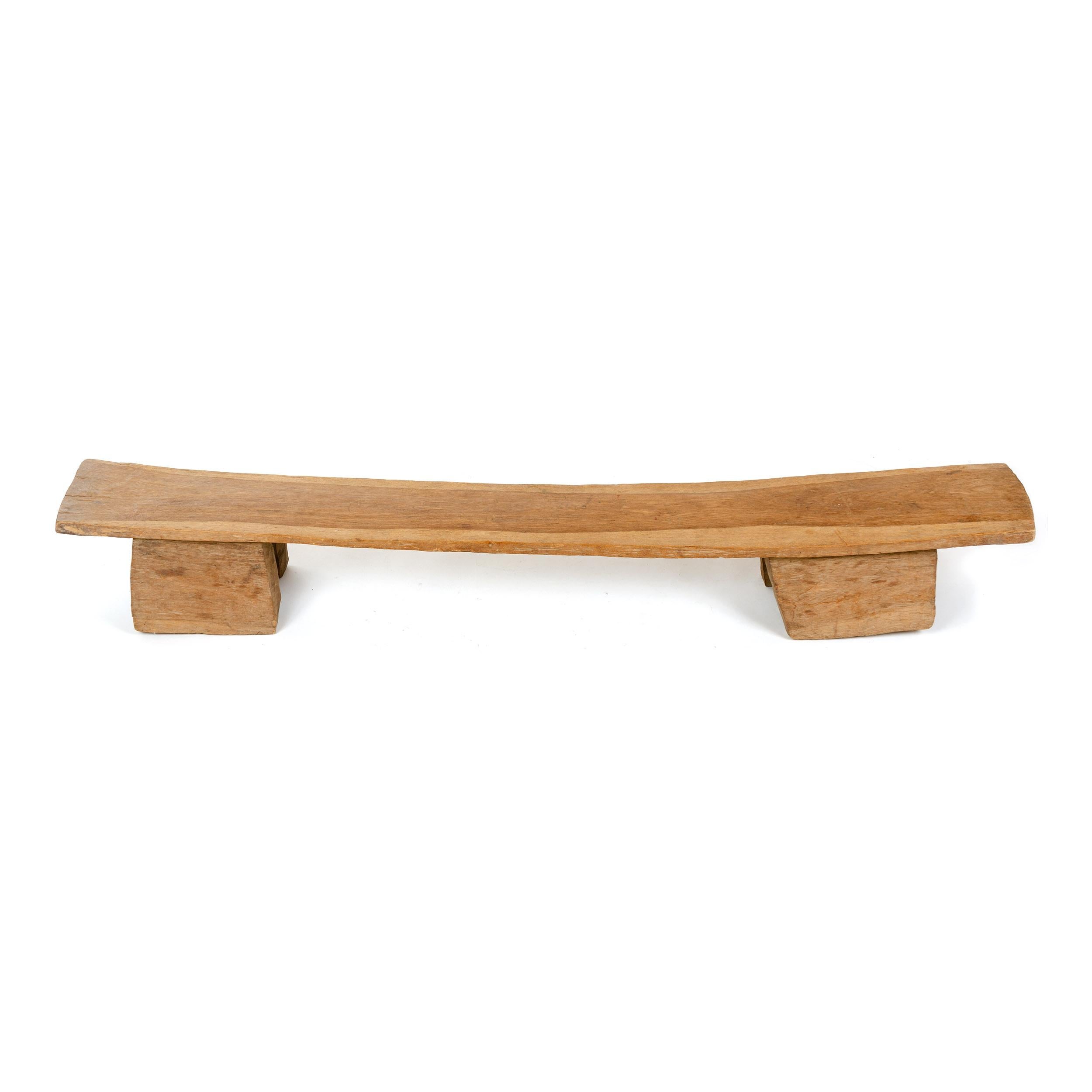 An African freeform bench carved of a single piece of wood on four legs.