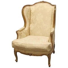 1920s Carved Wood Stuffed Wing Back Chair with Foral Cream Colored Upholstery