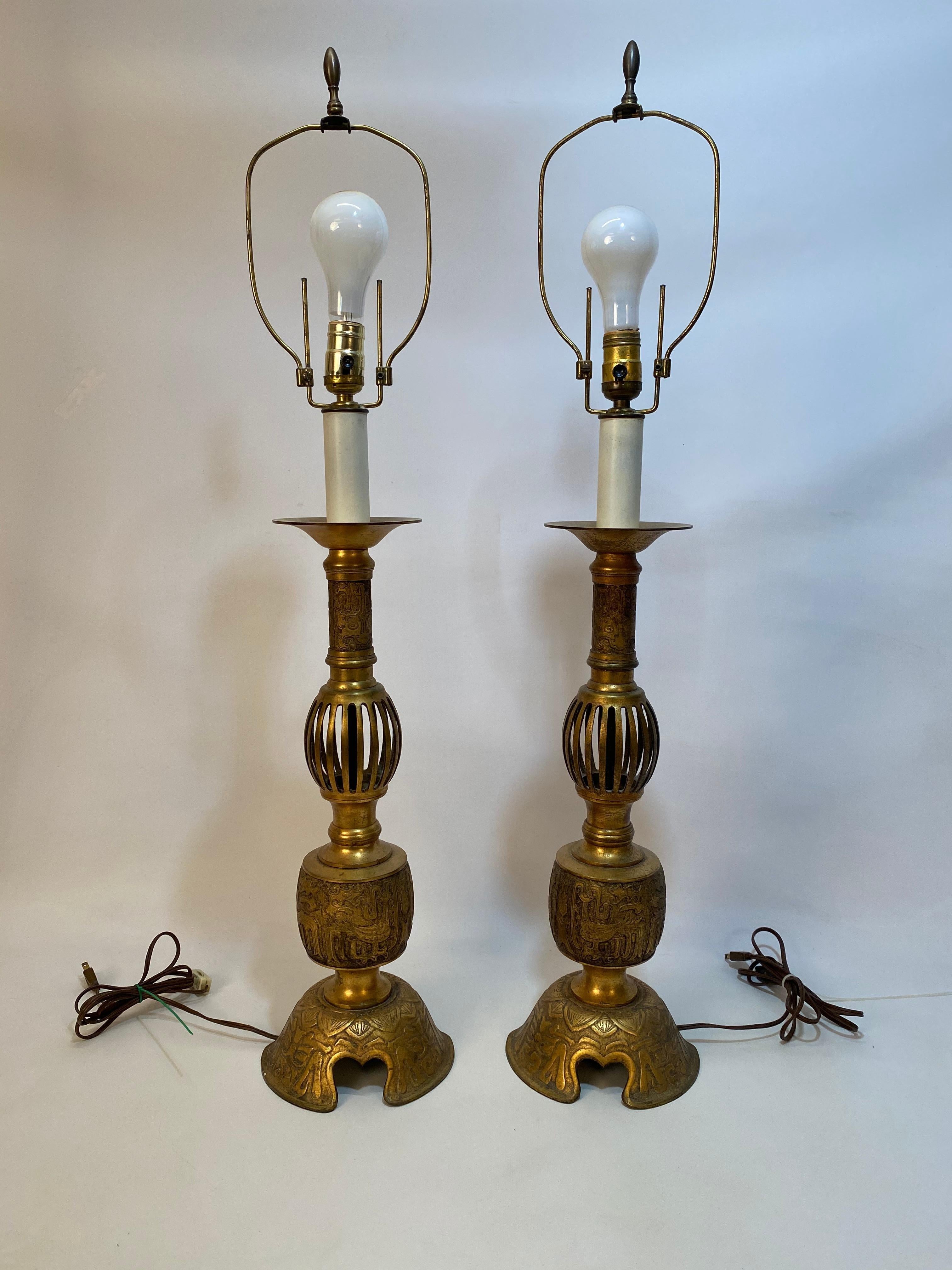 Wonderfully cast and detailed brass lamps. Tall candelabra design. Both signed Japan, circa 1920-1930. Ruffled fabric shades included.. Older wiring in good working condition. Older harps that are easily adjustable for shade height.

Approximately