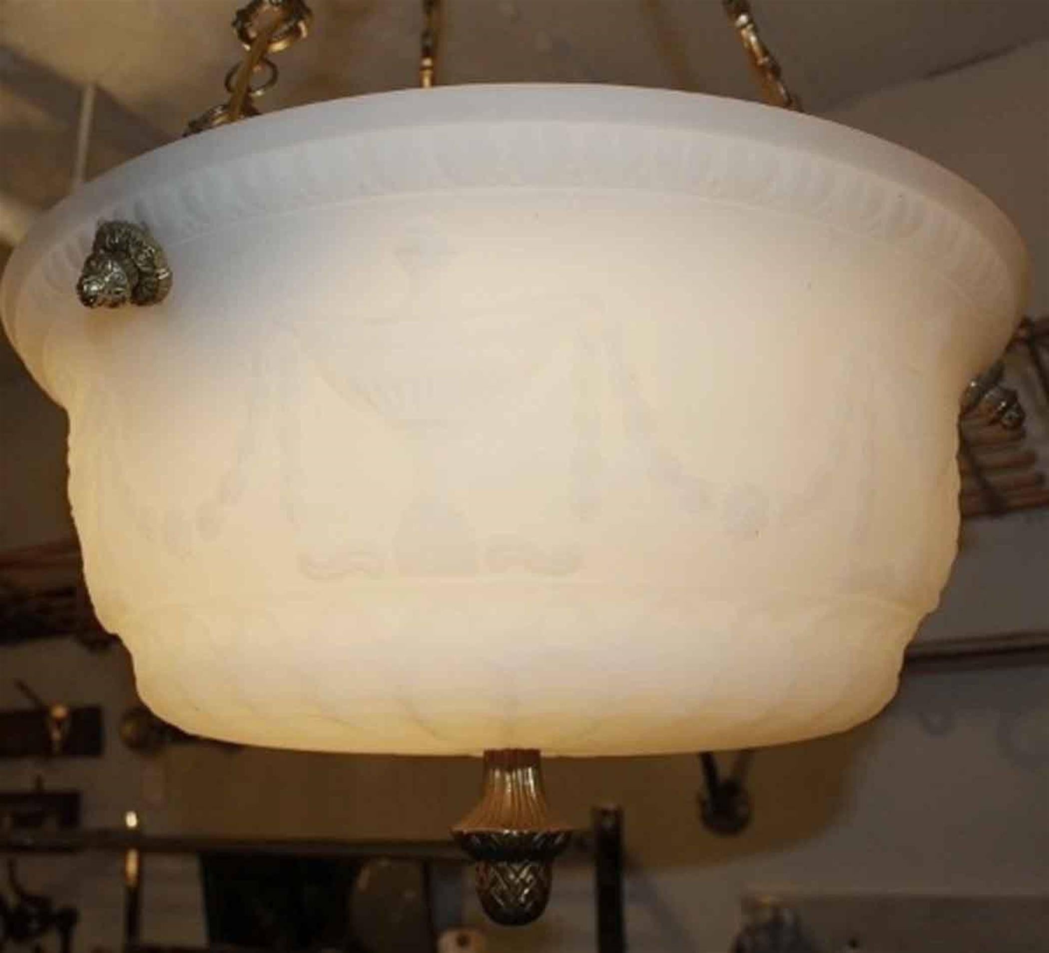 Decorative 1920s cast milk glass pendant light with an ornate brass canopy and chain. This can be seen at our 2420 Broadway location on the upper west side in Manhattan.